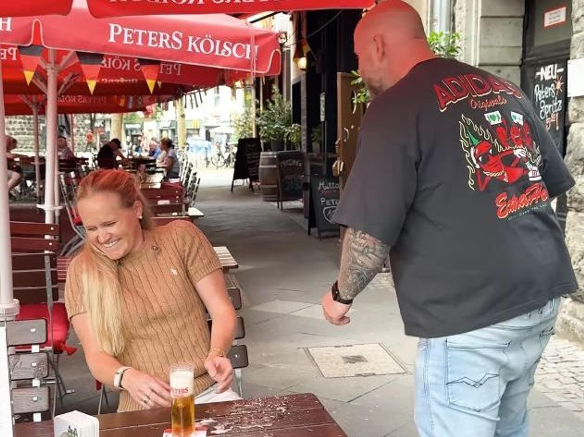 Ein Köbes und eine Kundin in einem Brauhaus in Köln