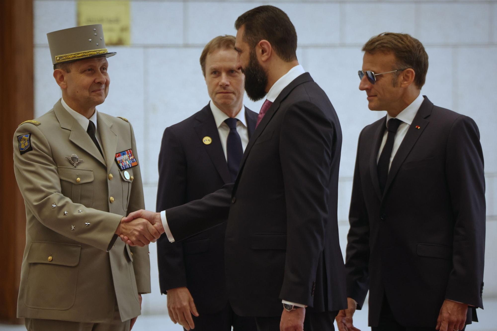 Der syrische Präsident Ahmed al-Scharaa (2.v.r) gibt einem französischen Offizier die Hand, während der französische Präsident Emmanuel Macron (r) bei ihrem Treffen danebensteht.