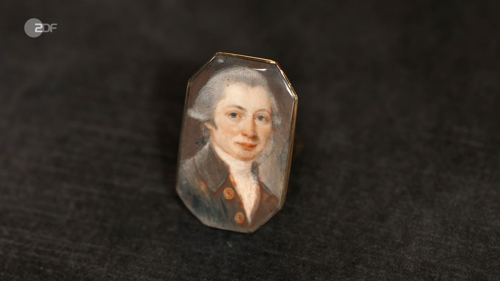 Einen Ring aus 333er Gold mit Gouache-Malerei wollte Tilman für 100 Euro veräußern. Wendela Horz erhöhte auf 600. Doch wer war porträtiert? „Mozart“, glaubte Fabian Kahl. David Suppes war sicher: „Ein alter Mann“. Wolfgang Pauritsch kaufte den Unbekannten für 370 Euro. (Bild: ZDF)