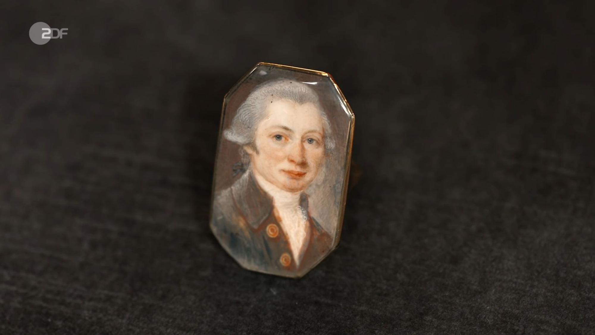 Einen Ring aus 333er Gold mit Gouache-Malerei wollte Tilman für 100 Euro veräußern. Wendela Horz erhöhte auf 600. Doch wer war porträtiert? „Mozart“, glaubte Fabian Kahl. David Suppes war sicher: „Ein alter Mann“. Wolfgang Pauritsch kaufte den Unbekannten für 370 Euro. (Bild: ZDF)