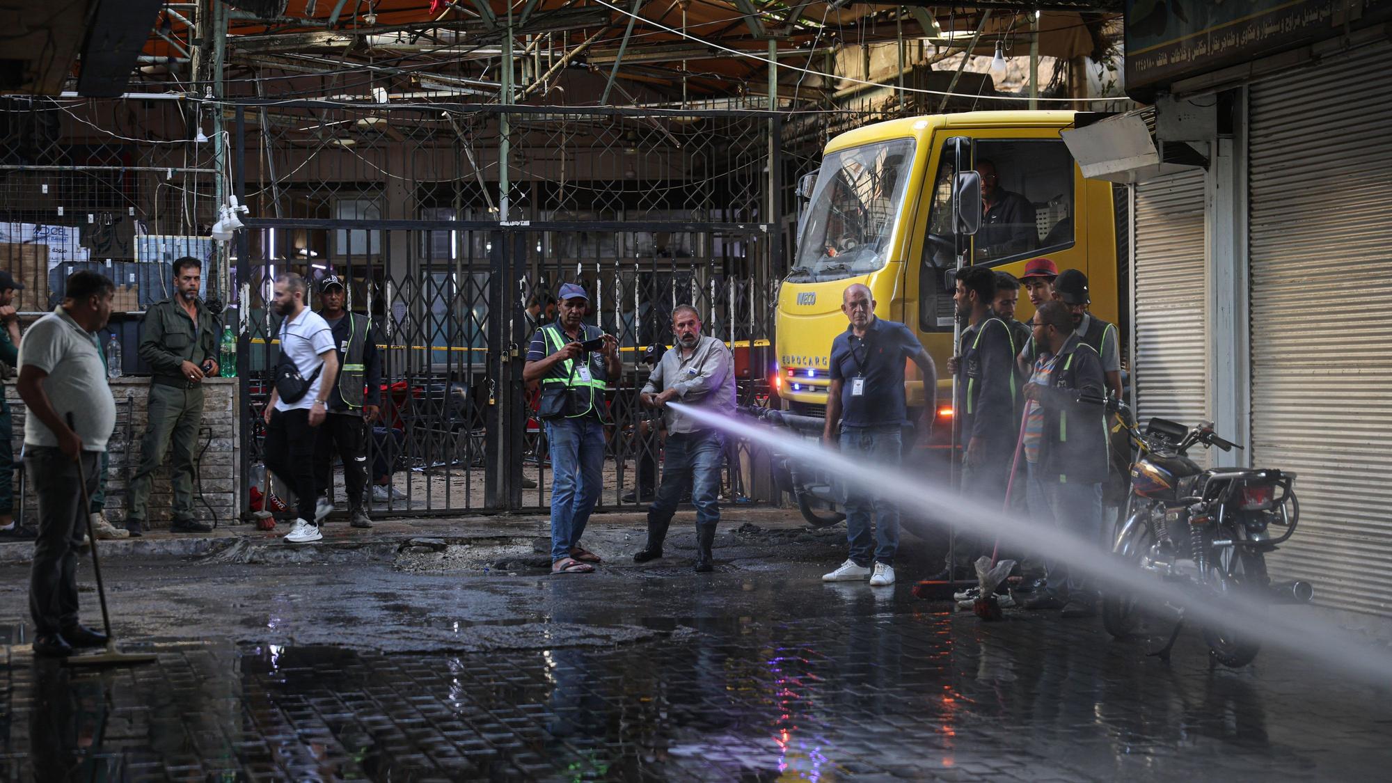 Arbeiter spritzen Wasser am Tatort, hier kam es zu einer Explosion im Zentrum der syrischen Hauptstadt.