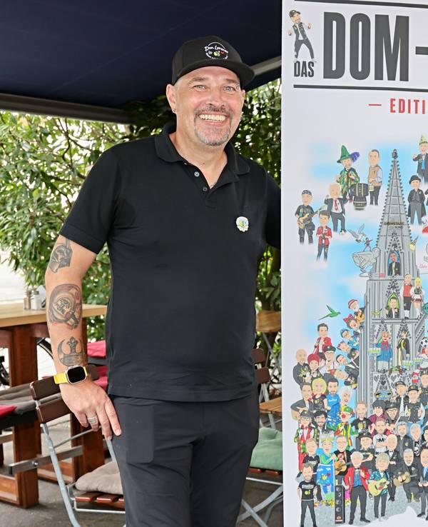 Don Lorenzo zeigt sein neues Dom-Poster.