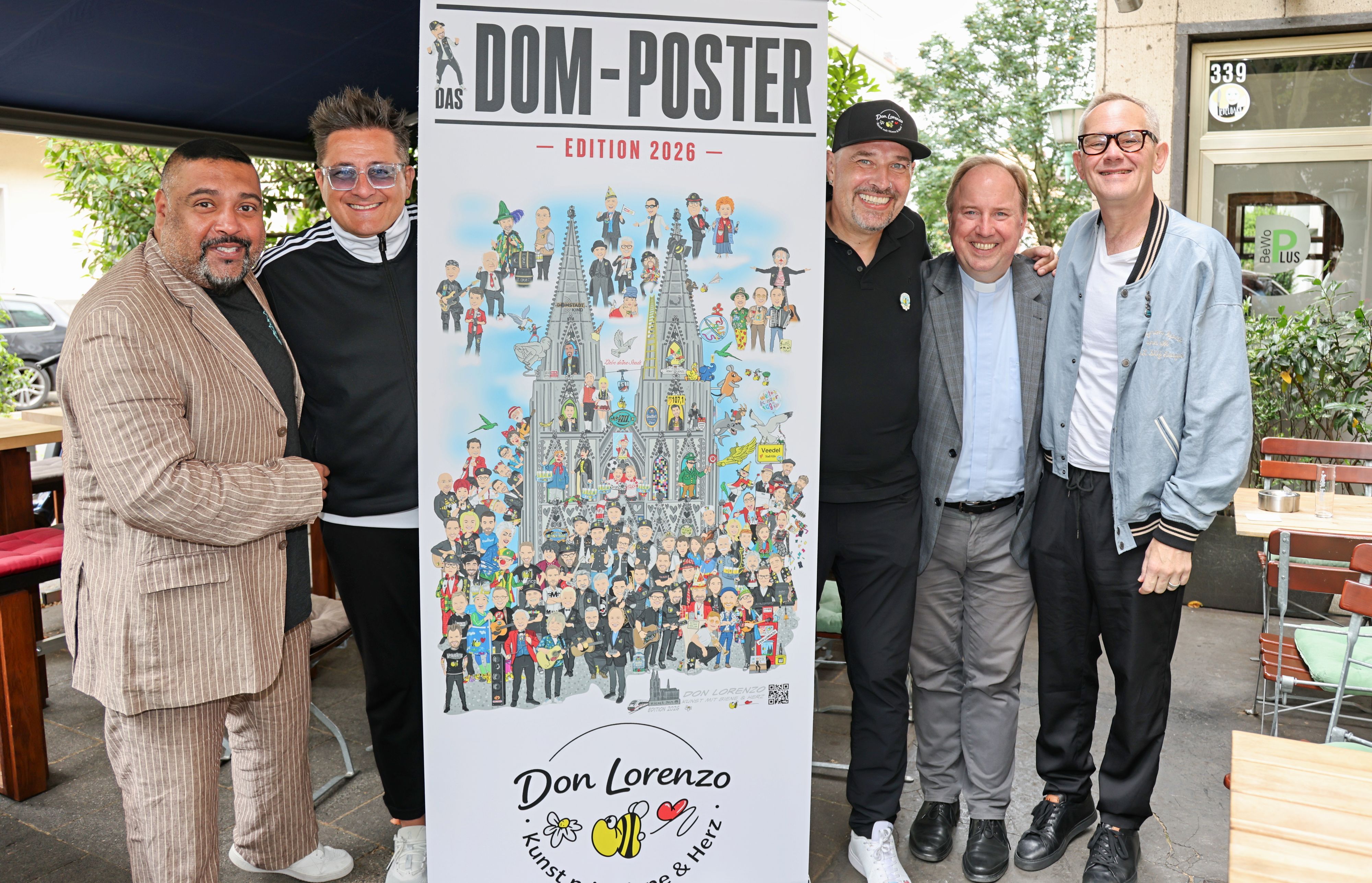 Elvis Katticaren, Micky Nauber, Don Lorenzo, Msgr. Robert Kleine und JP Weber zeigen das Poster.