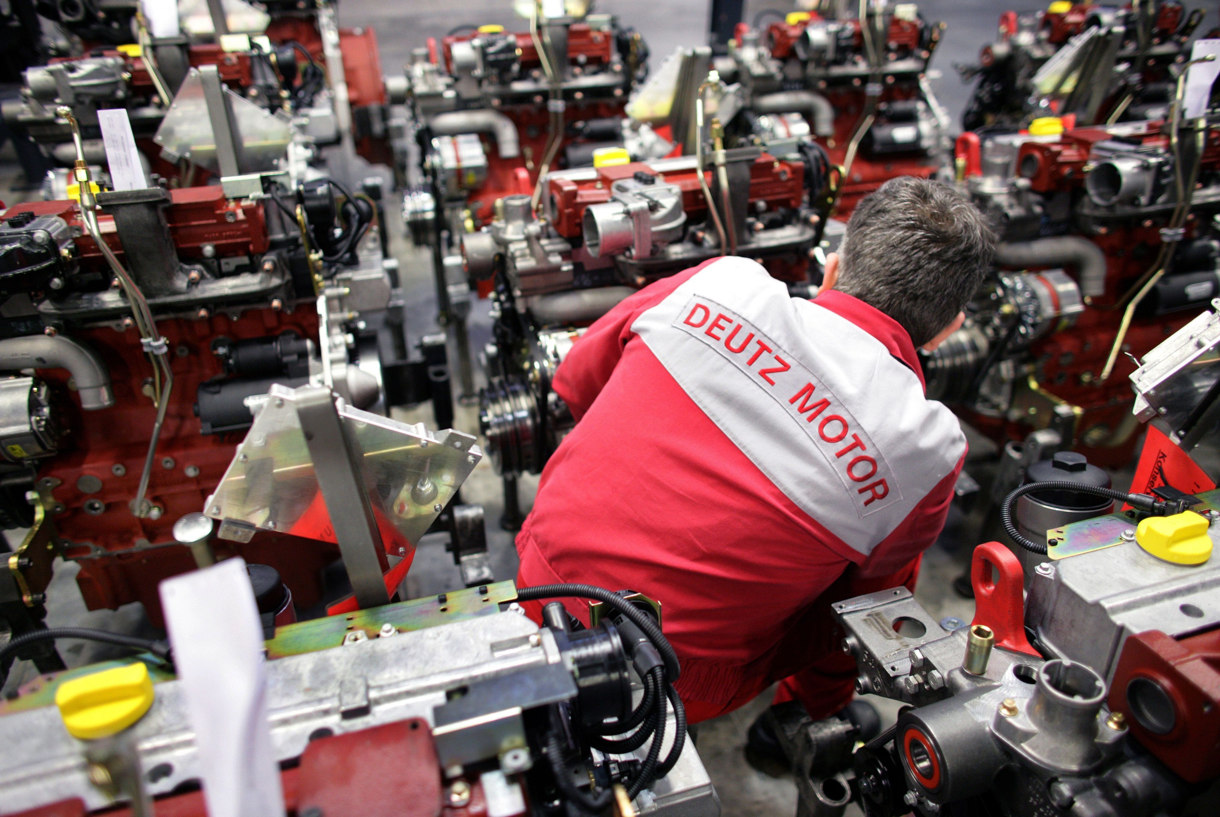 Ein Mitarbeiter der Deutz AG schraubt in Köln an einem Motor.