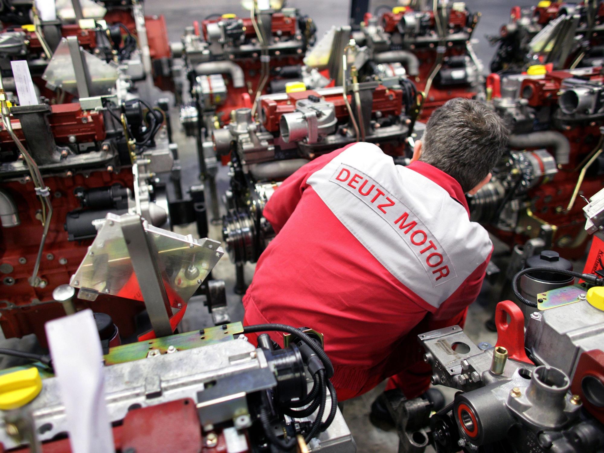 Ein Mitarbeiter der Deutz AG schraubt in Köln an einem Motor.
