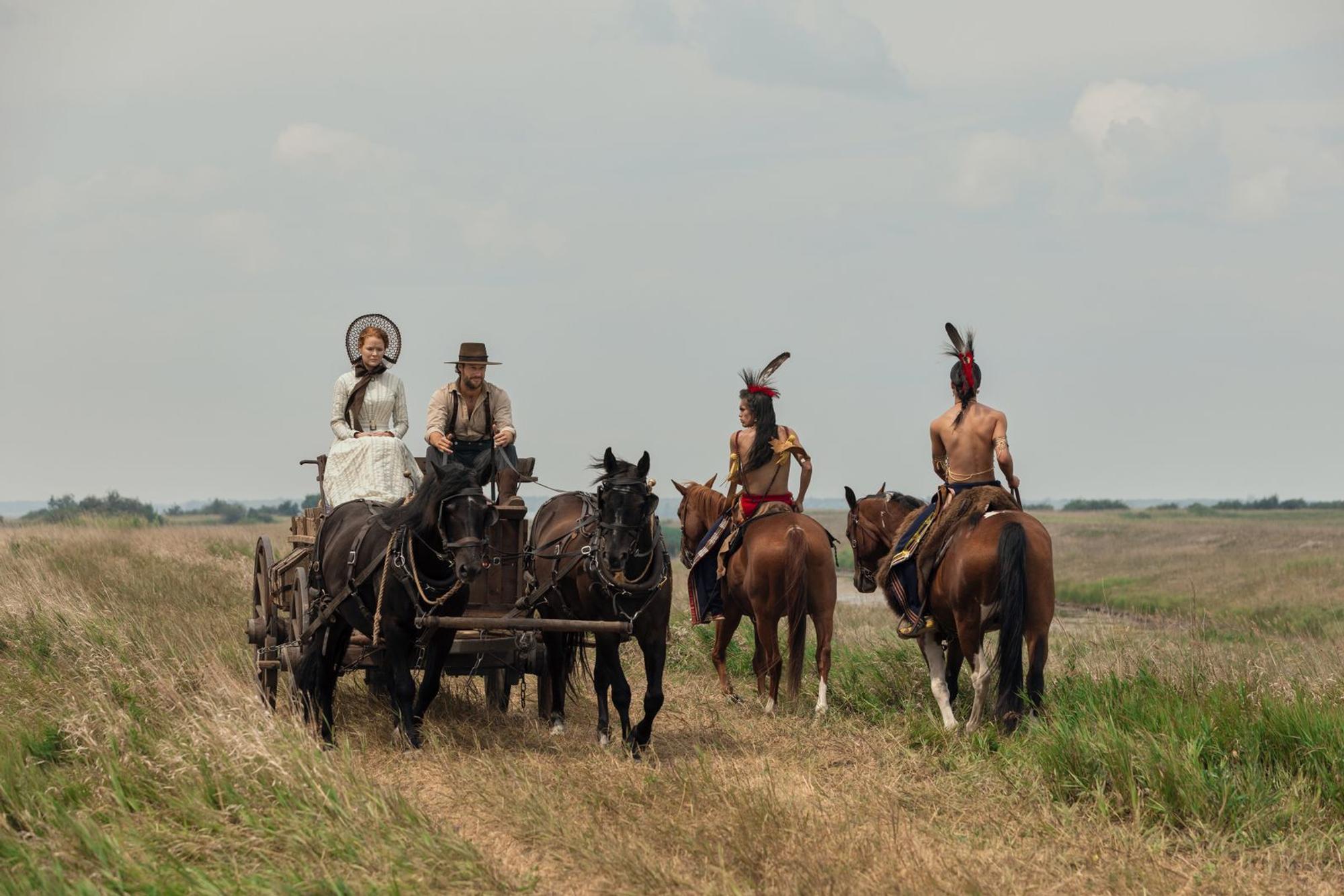 An Begegnungen mit Indigenen müssen sich Caroline (Crosby Fitzgerald) und Charles (Luke Bracey, zweiter von rechts) noch gewöhnen. Kansas war zur Zeit ihrer Ankunft „Indianerland“.
(Bild: Eric Zachanowich/Netflix © 2026)