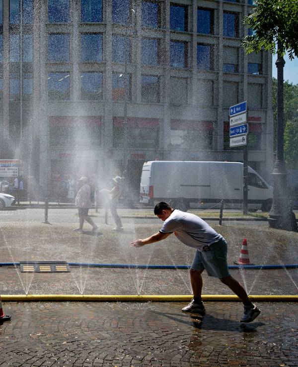 Passanten genießen Ende Juni Wasserfontänen, die im Rahmen der Hitzeaktion „Cooling Cologne“ der Stadt Köln auf dem Rudolfplatz in der Innenstadt installiert wurden.