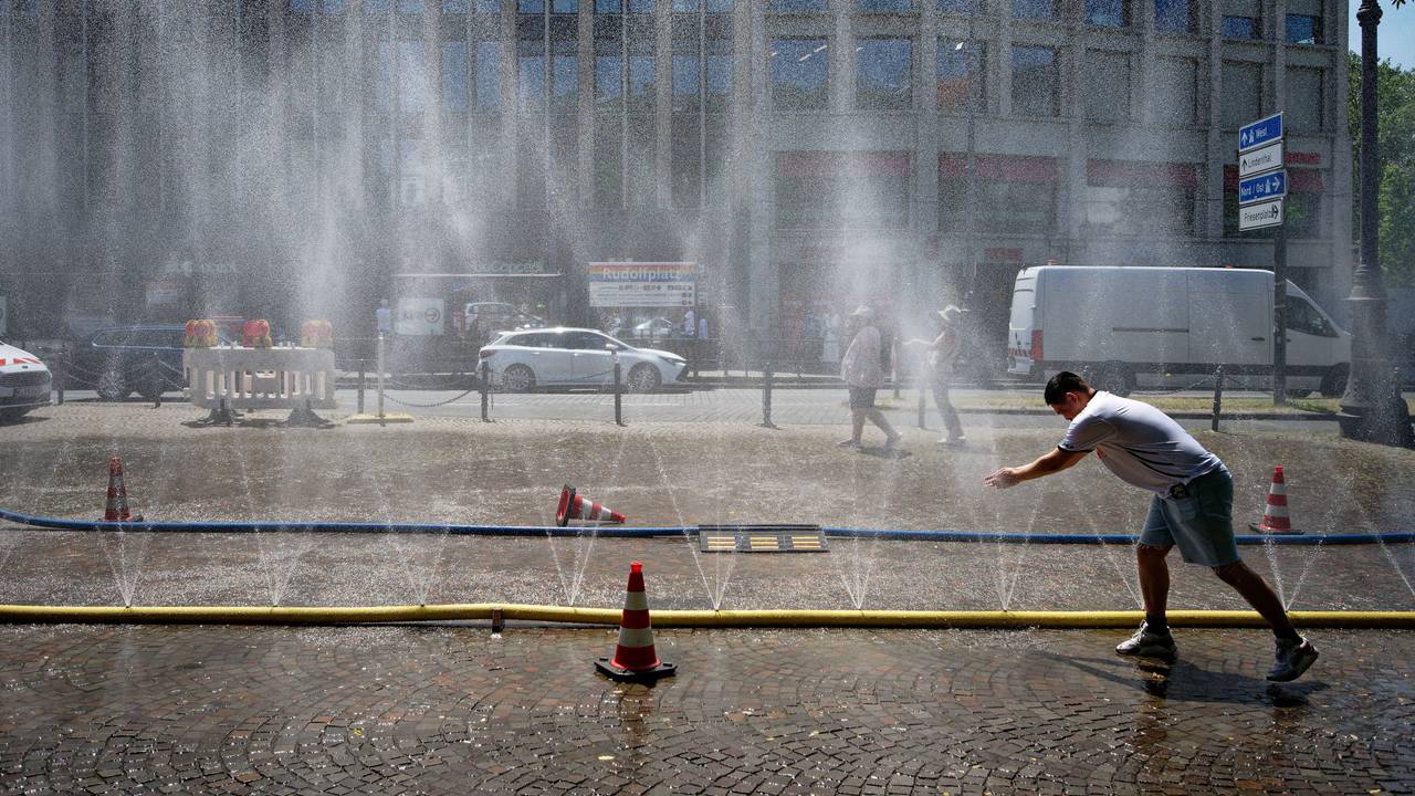 Passanten genießen Ende Juni Wasserfontänen, die im Rahmen der Hitzeaktion „Cooling Cologne“ der Stadt Köln auf dem Rudolfplatz in der Innenstadt installiert wurden.
