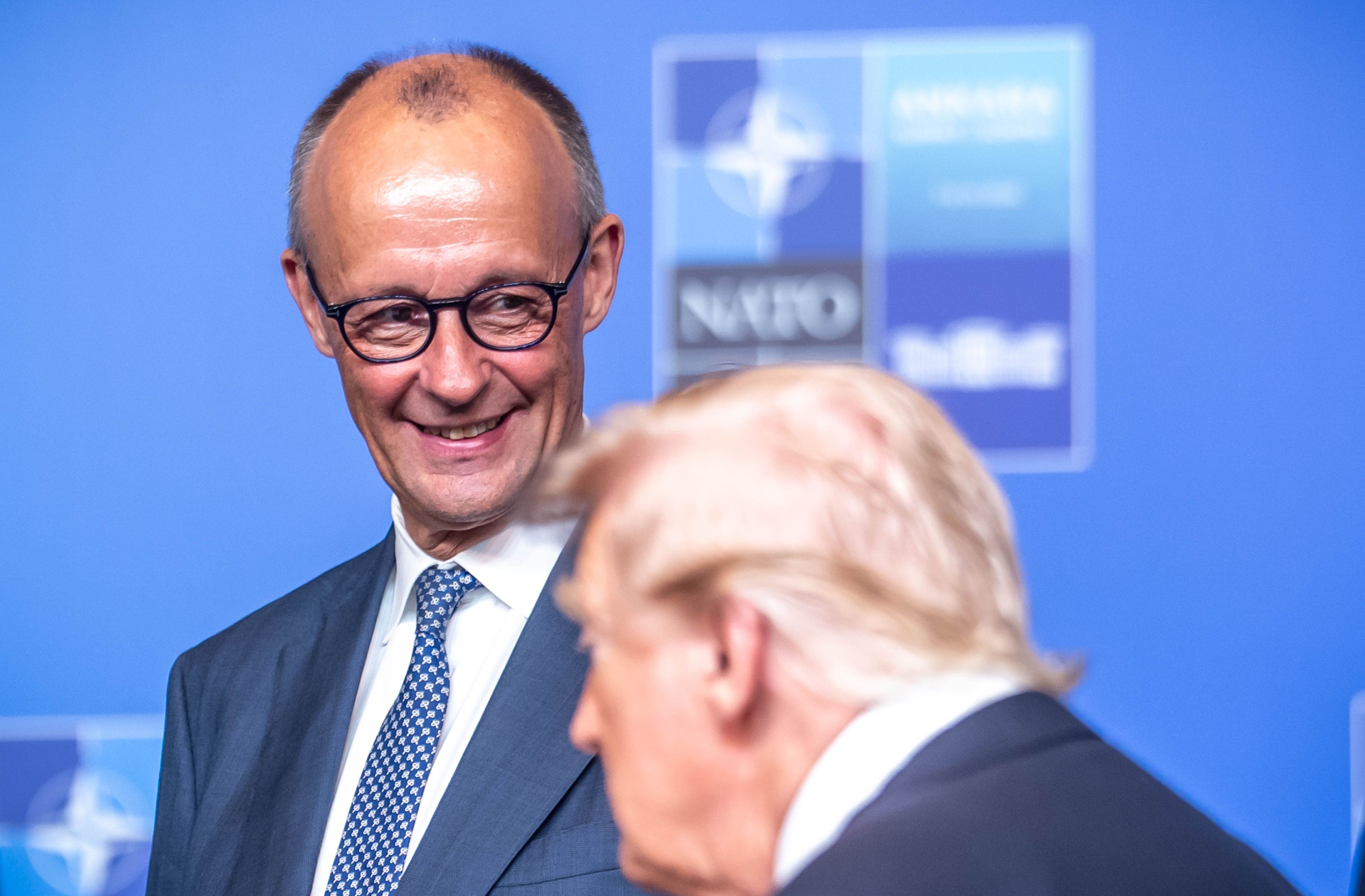 Bundeskanzler Friedrich Merz (CDU) steht beim Familienfoto hinter US-Präsident Donald Trump.