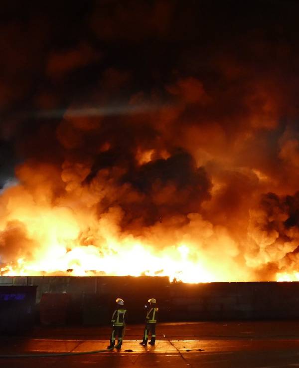 Feuerwehrleute bekämpfen einen Brand auf einem Wertstoffhof im Rhein-Sieg-Kreis. Dort hat eine große Menge Kunststoffmüll Feuer gefangen.