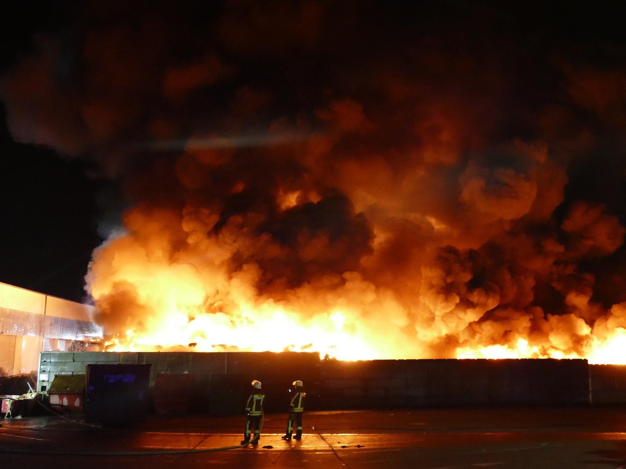 Feuerwehrleute bekämpfen einen Brand auf einem Wertstoffhof im Rhein-Sieg-Kreis. Dort hat eine große Menge Kunststoffmüll Feuer gefangen.