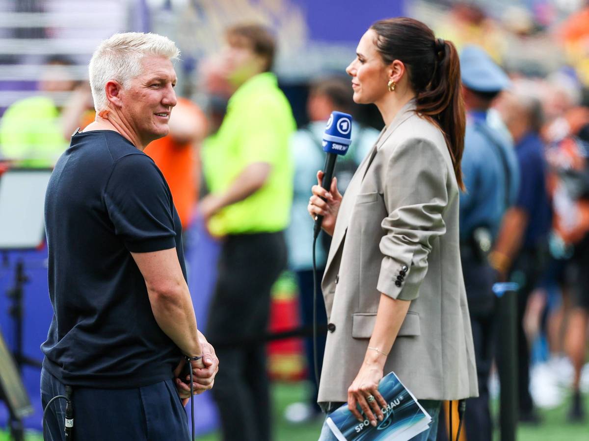 Bastian Schweinsteiger blickt sich neben Esther Sedlaczek bei der WM 2026 um.