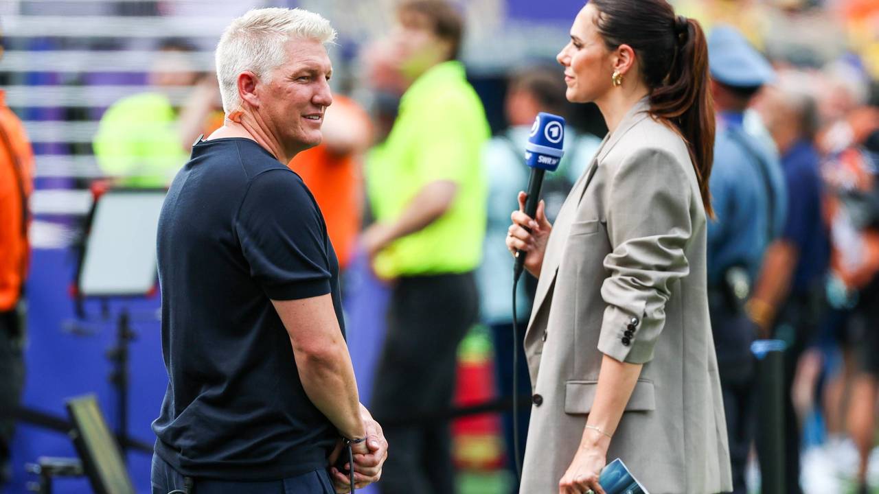 Bastian Schweinsteiger blickt sich neben Esther Sedlaczek bei der WM 2026 um.