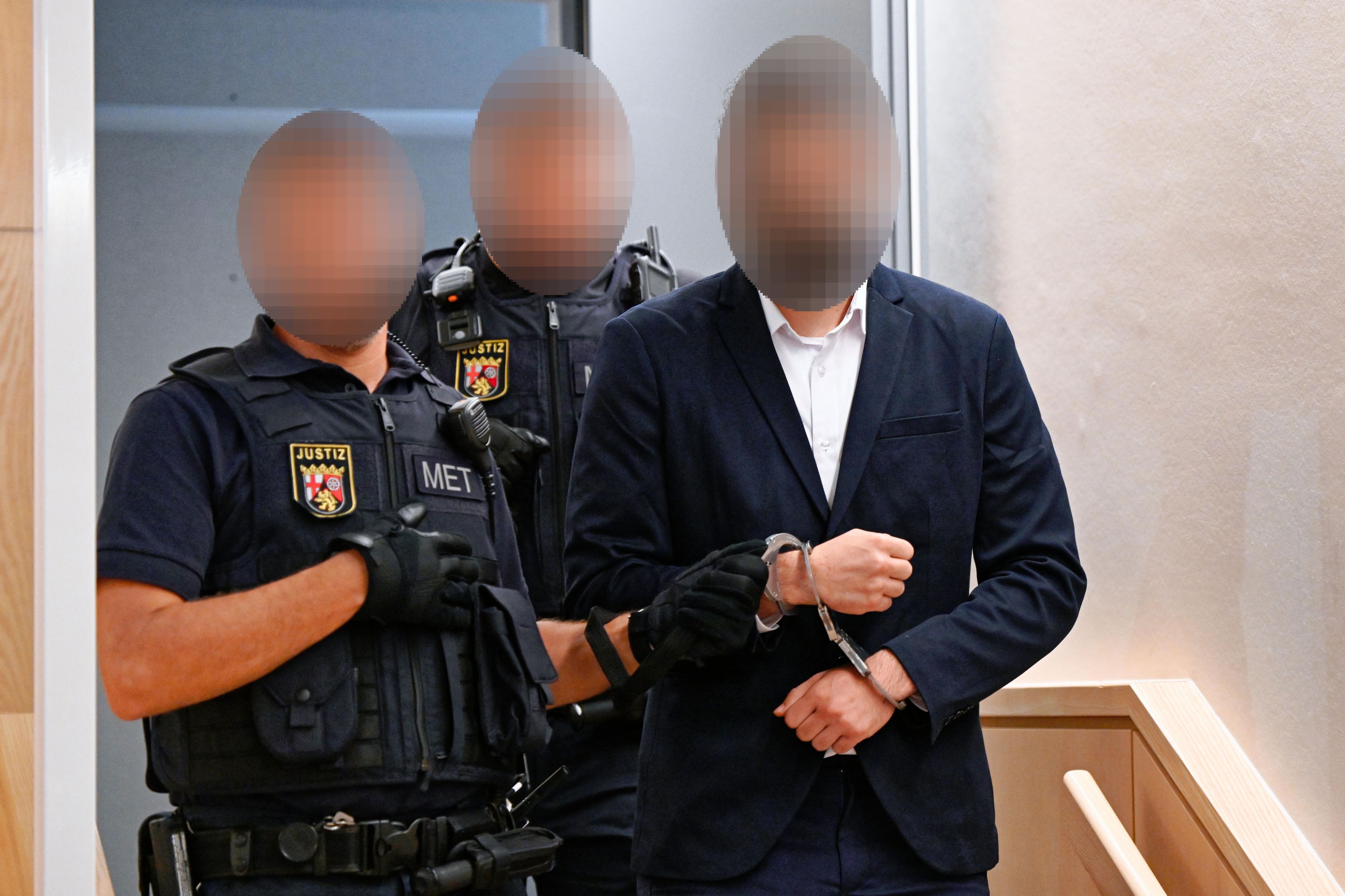 Ein Mann wird von Beamten in den Verhandlungssaal des Landgerichts Zweibrücken geführt.