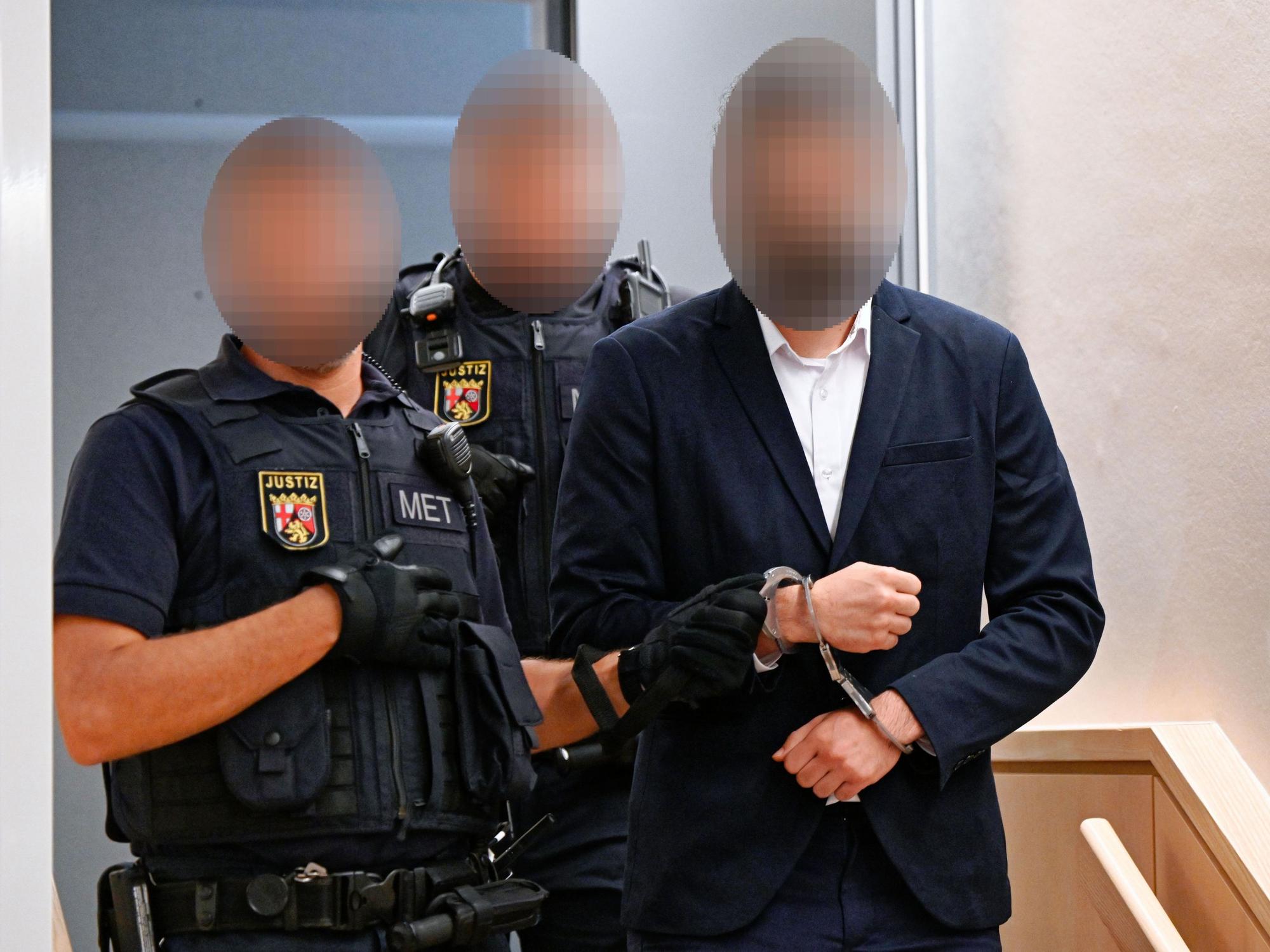 Ein Mann wird von Beamten in den Verhandlungssaal des Landgerichts Zweibrücken geführt.