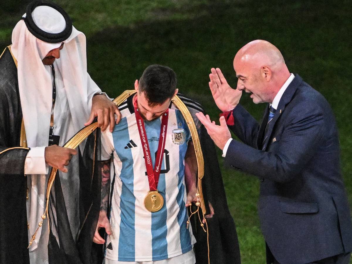 Der Emir von Katar, Scheich Tamim bin Hamad Al Thani, legt Argentiniens Lionel Messi vor Übergabe des WM-Pokals vor Fifa-Präsident Gianni Infantino ein Bischt, ein traditionelles arabische Kleidungsstück an.