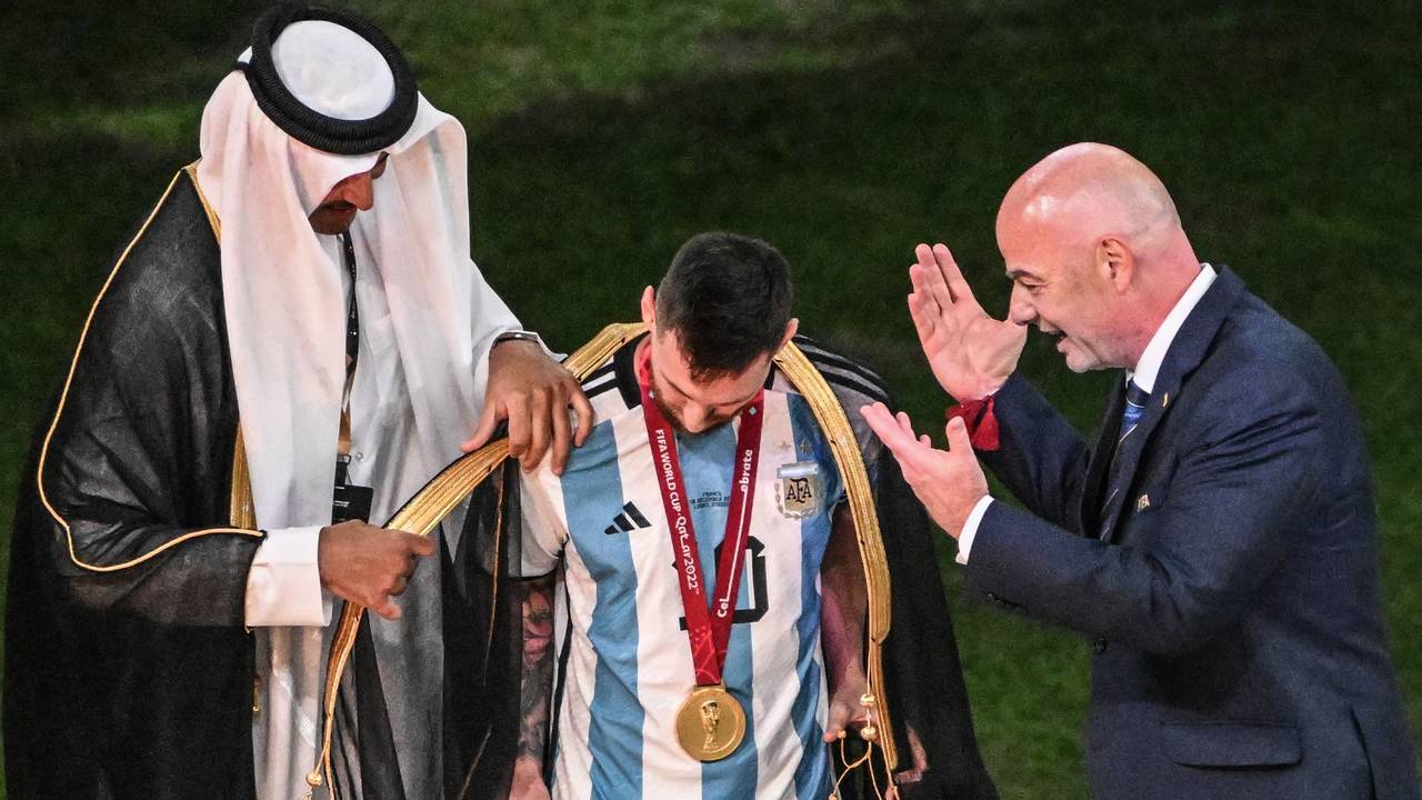 Der Emir von Katar, Scheich Tamim bin Hamad Al Thani, legt Argentiniens Lionel Messi vor Übergabe des WM-Pokals vor Fifa-Präsident Gianni Infantino ein Bischt, ein traditionelles arabische Kleidungsstück an.