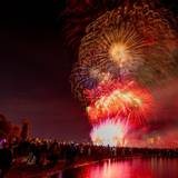 Menschen besuchen im Kölner Rheinpark das größte musiksynchrone Feuerwerk Europas.