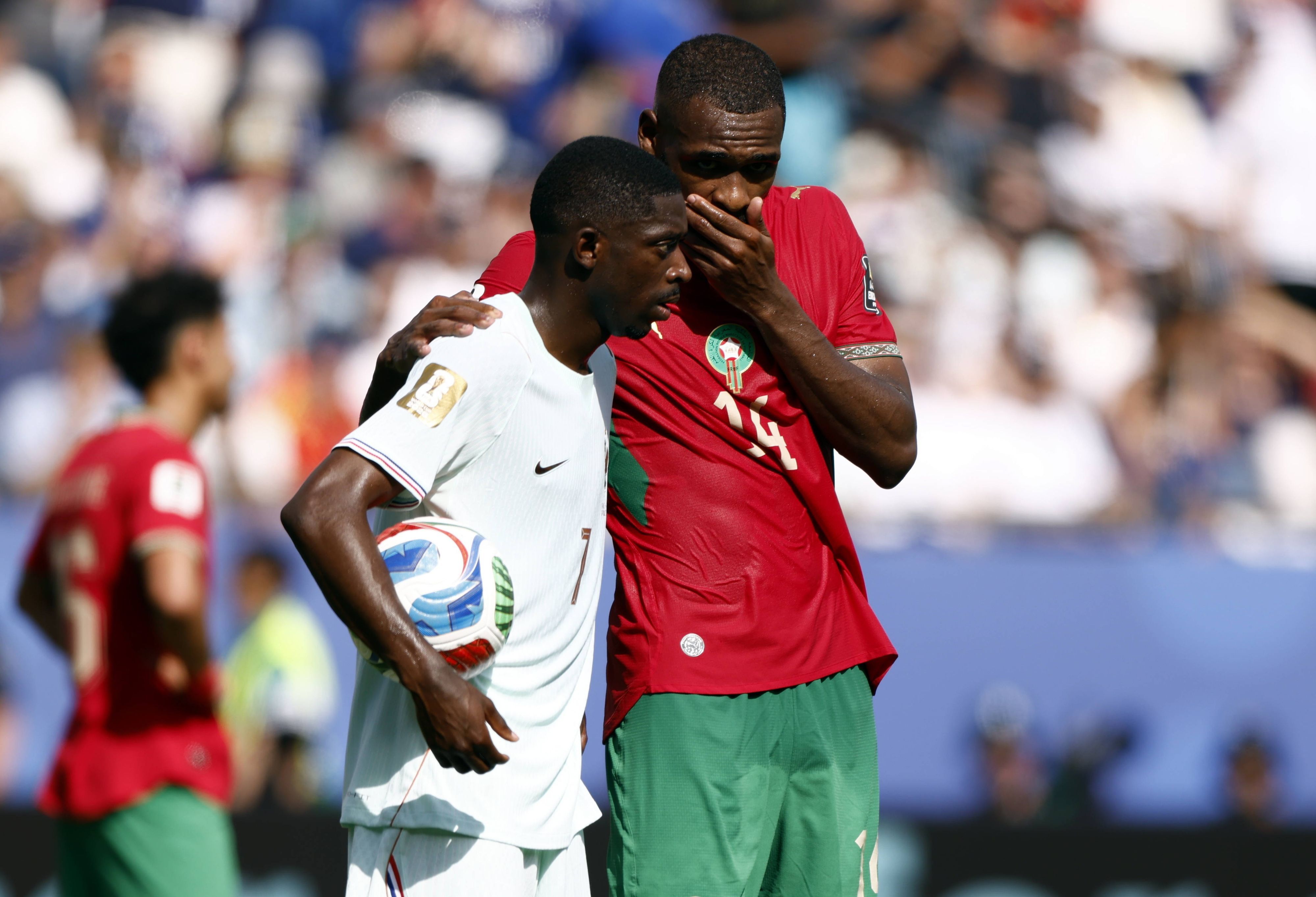 Issa Diop hält sich im Gespräch mit Ousmane Dembélé die Hand vor den Mund.