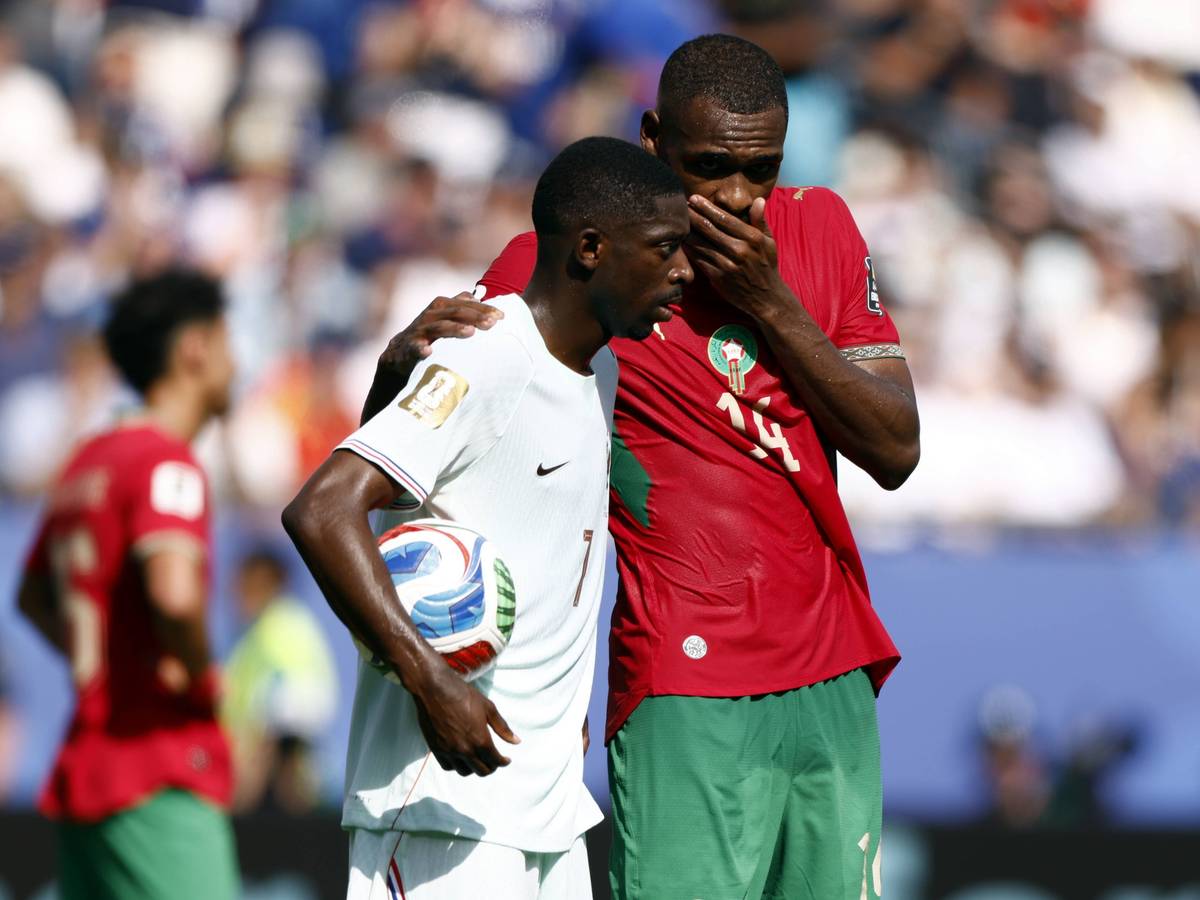Issa Diop hält sich im Gespräch mit Ousmane Dembélé die Hand vor den Mund.