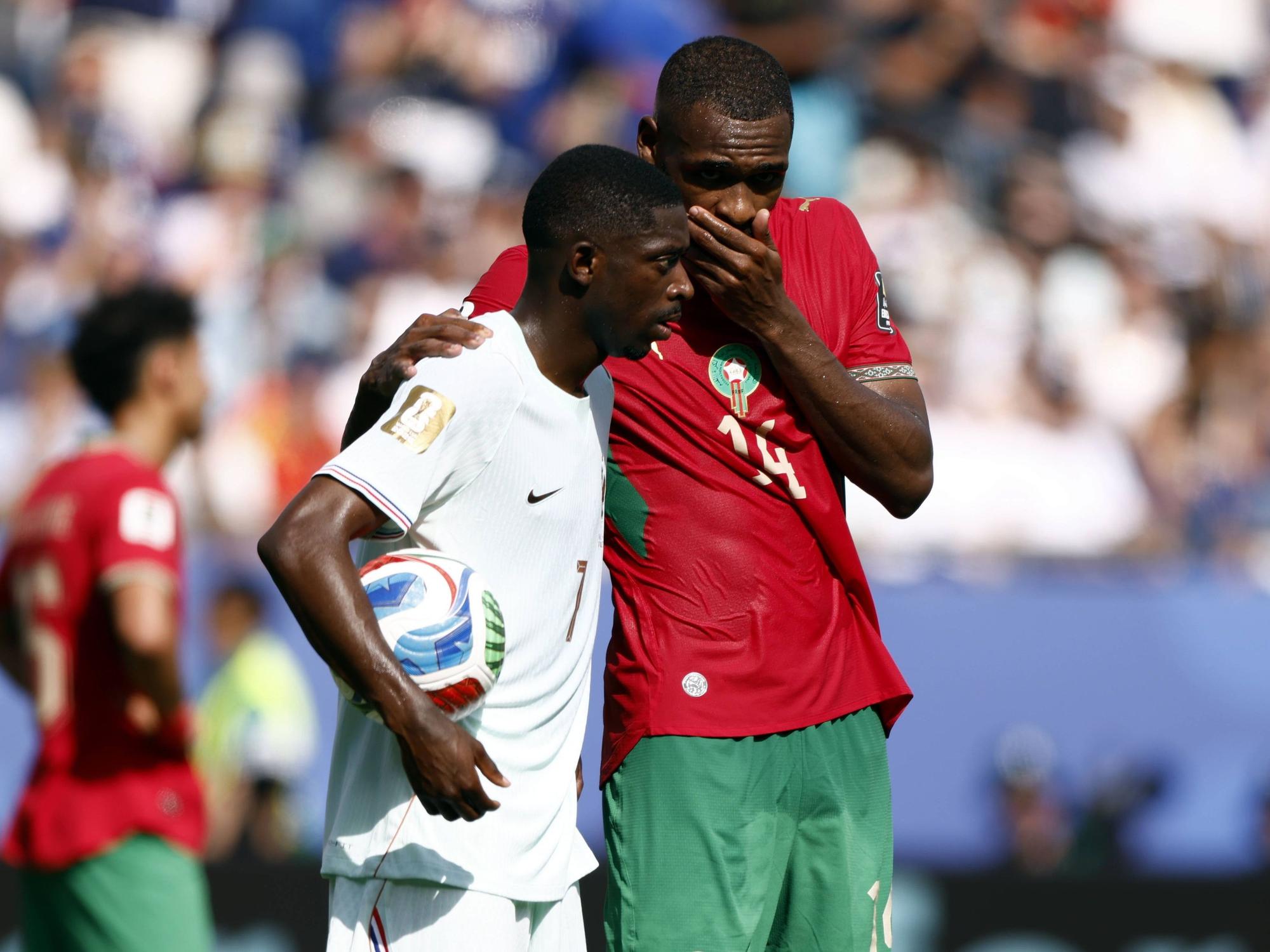 Issa Diop hält sich im Gespräch mit Ousmane Dembélé die Hand vor den Mund.