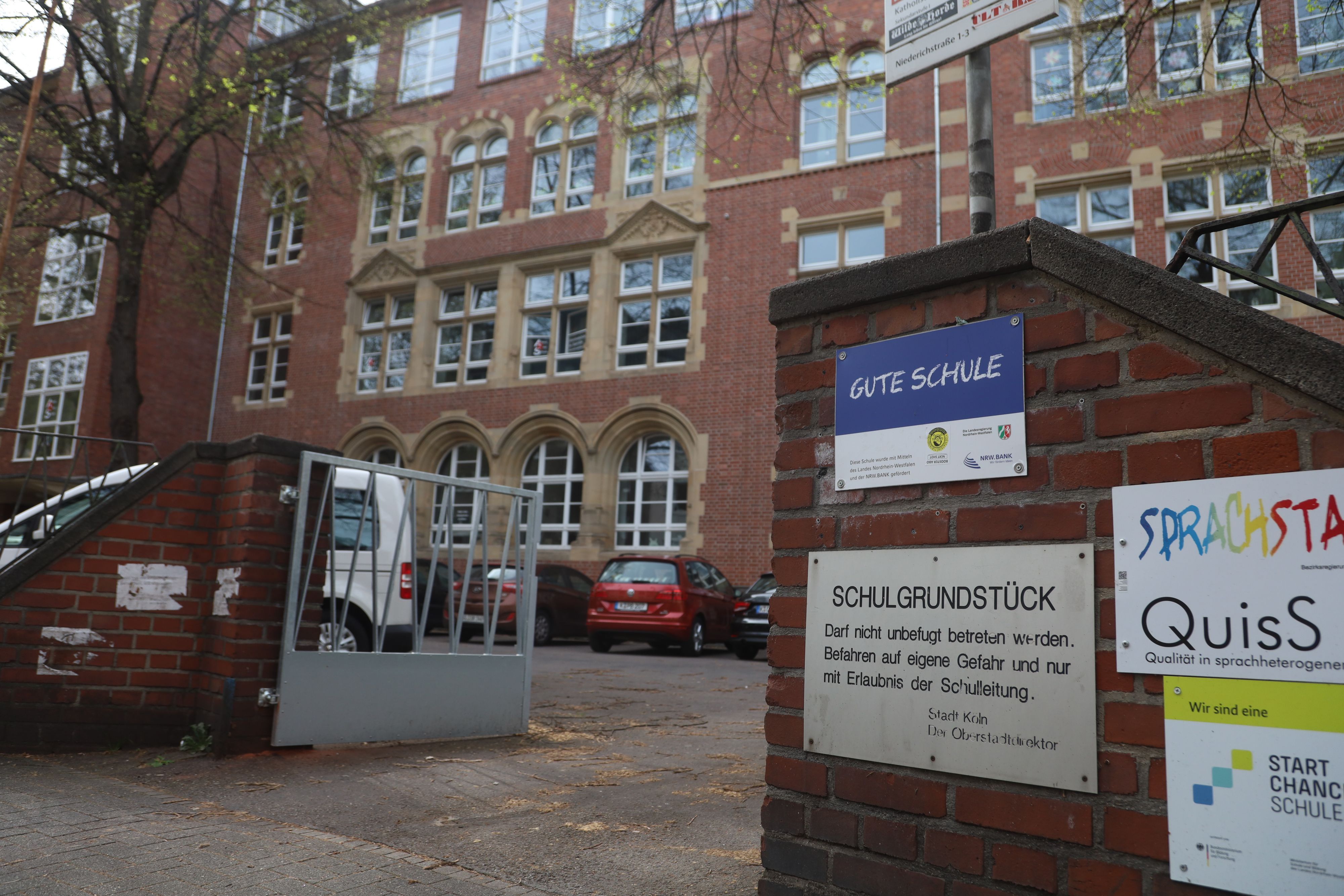 Ein Verbotsschild untersagt den Zutritt für unbefugte Personen zum Schulhof der Städtischen Katholischen Hauptschule am Rhein.