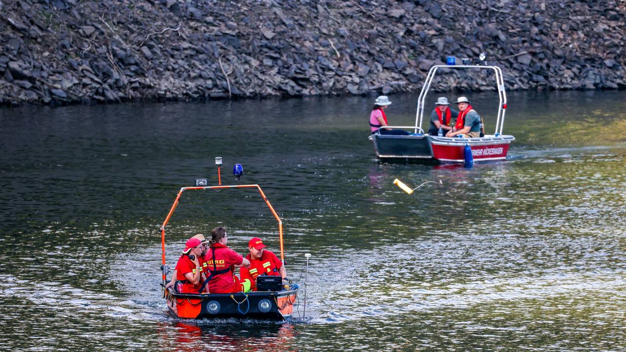 Boote der Deutschen Lebens-Rettungs-Gesellschaft (DLRG) und der Feuerwehr fahren am 12. Juli bei der Suche nach einer vermissten Person in der Wuppertalsperre auf dem Wasser entlang.