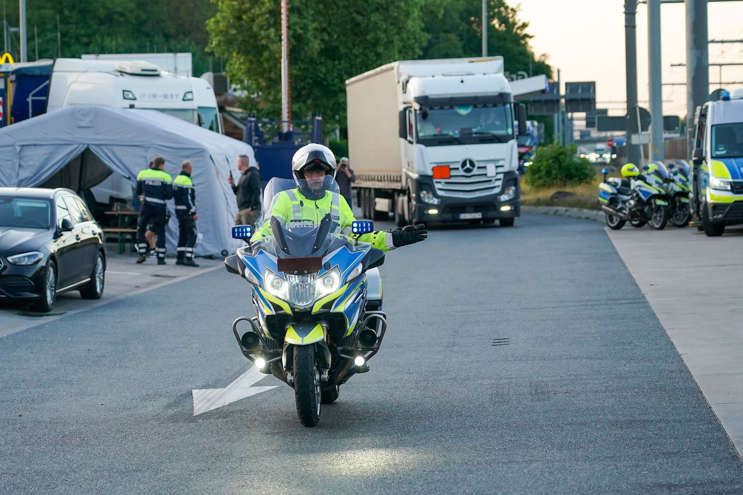 Ein Motorrad-Polizist vor einem Lkw.
