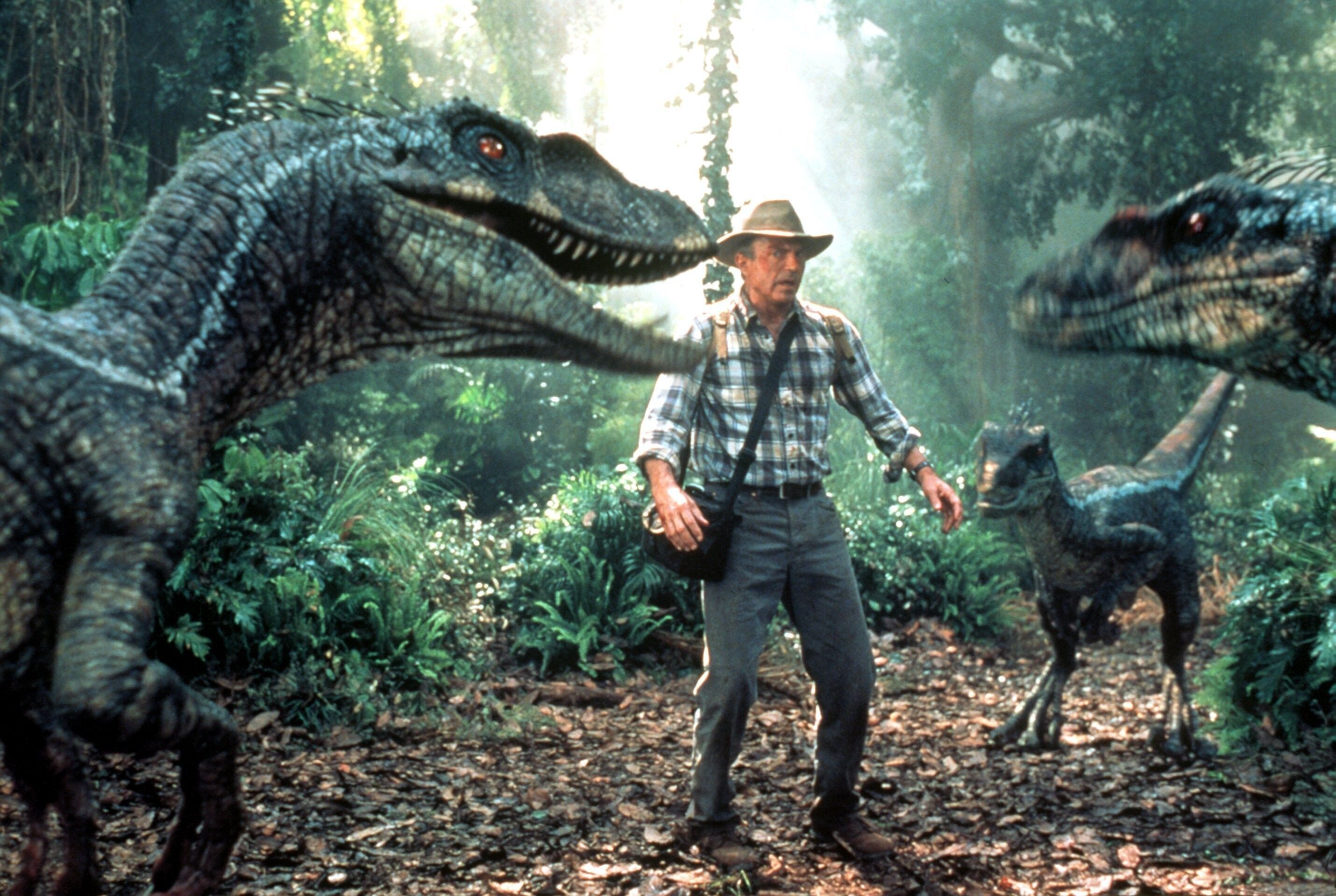 Der Paläontologe Alan Grant (Sam Neill) findet sich in dieser Filmszene von „Jurassic Park III“ plötzlich von einer Gruppe Dinosauriern umringt.
