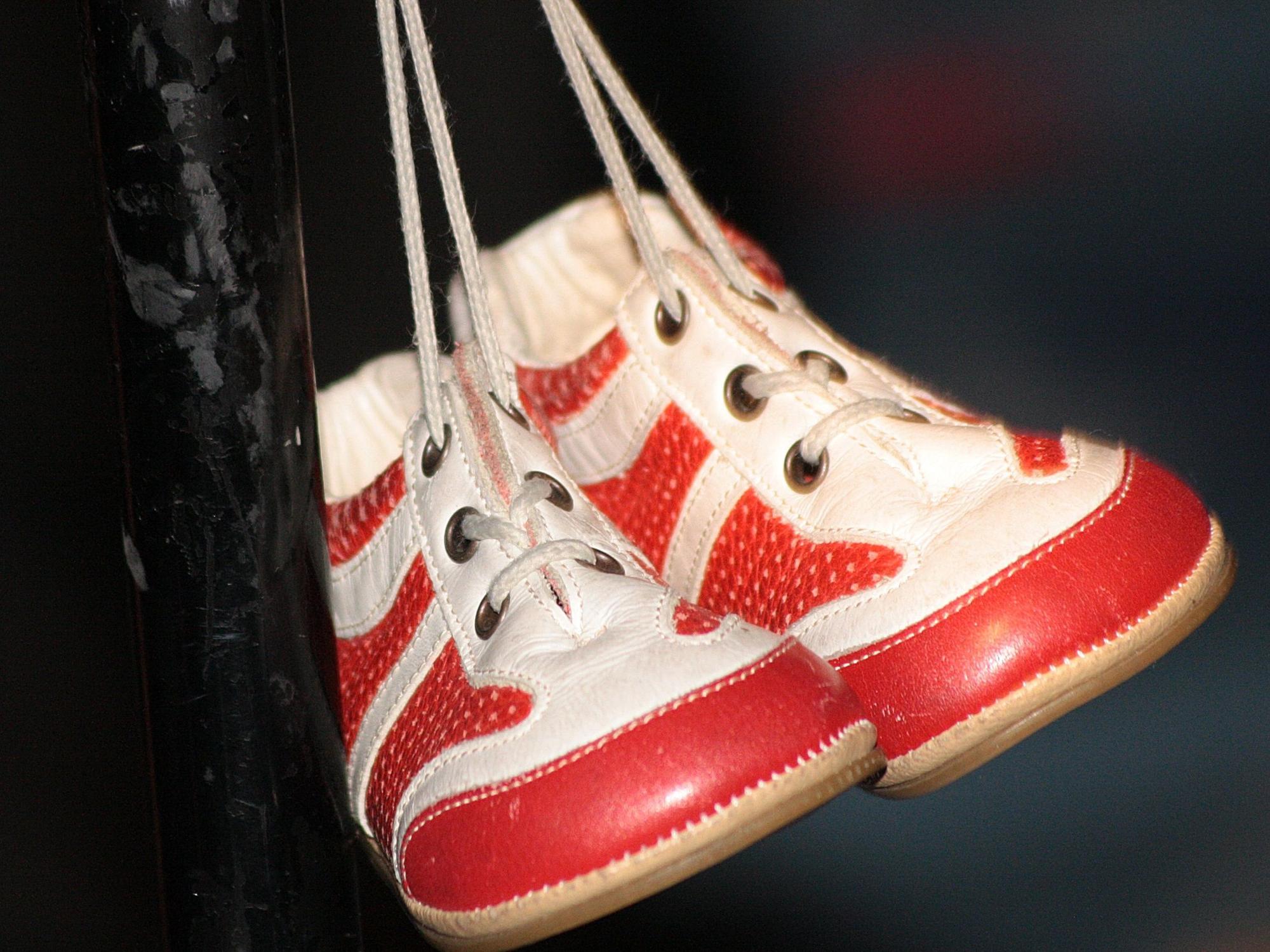 Rot-weiße Babyschuhe hängen am Mikrofonständer von Micky Nauber.