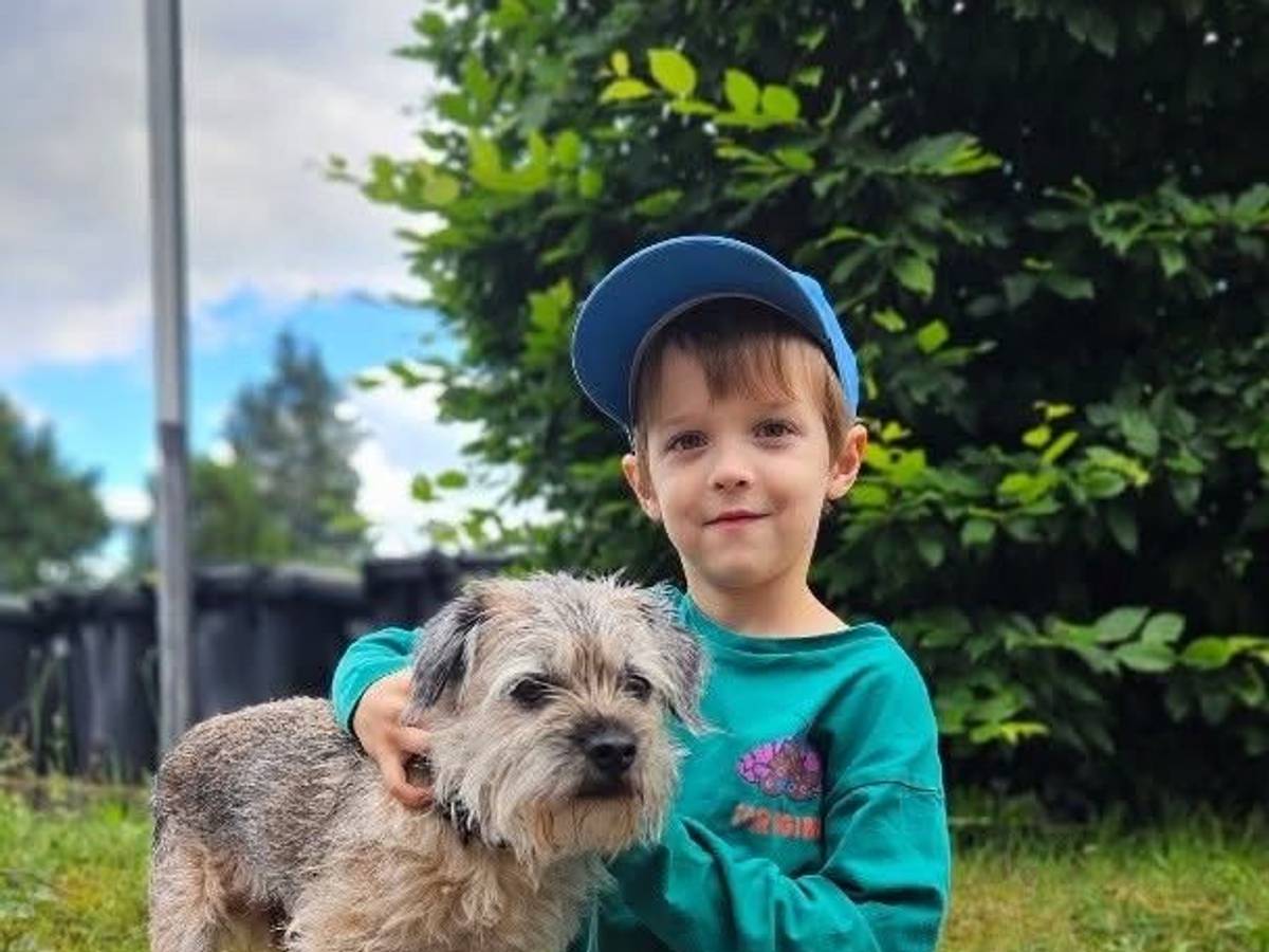 Bruno sitzt neben einem kleinen Hund.