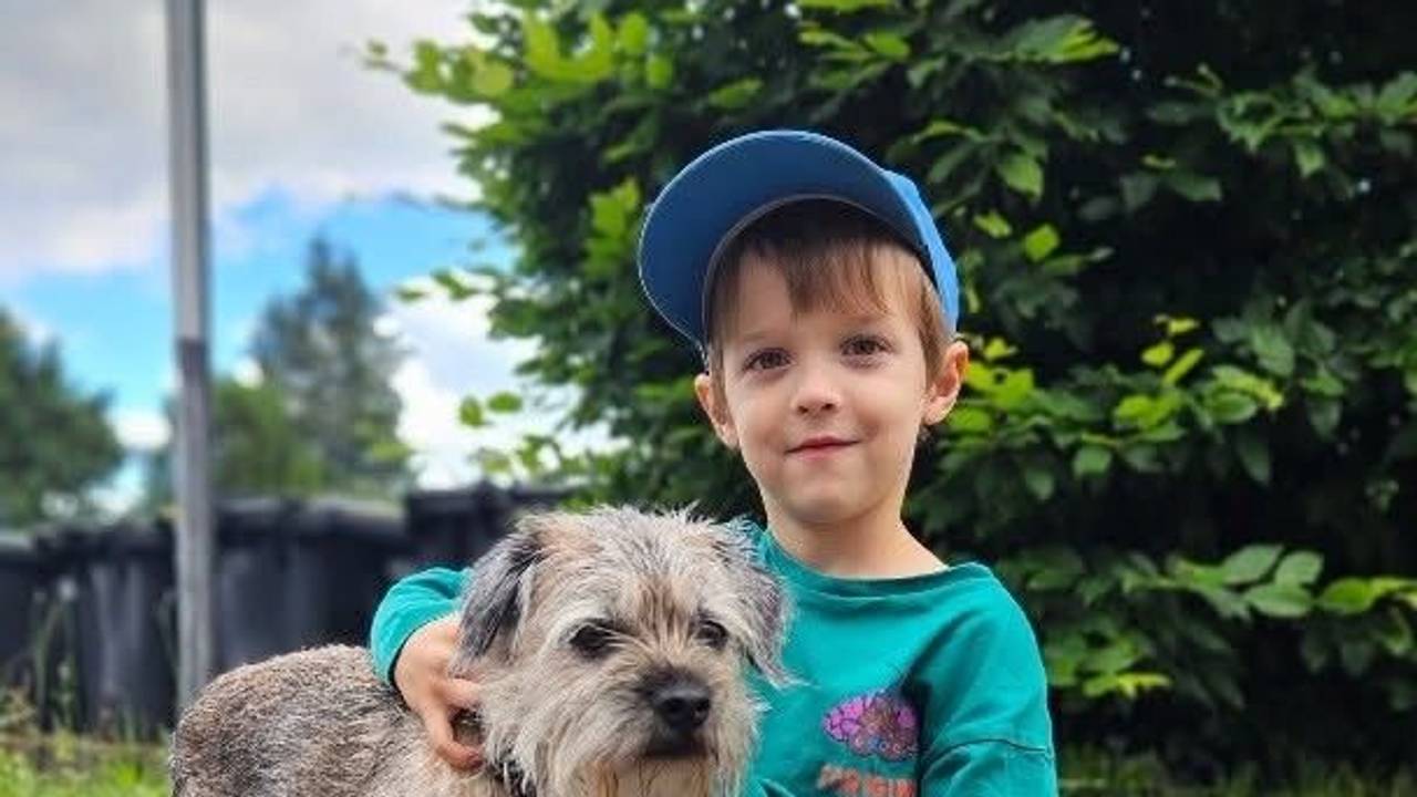 Bruno sitzt neben einem kleinen Hund.