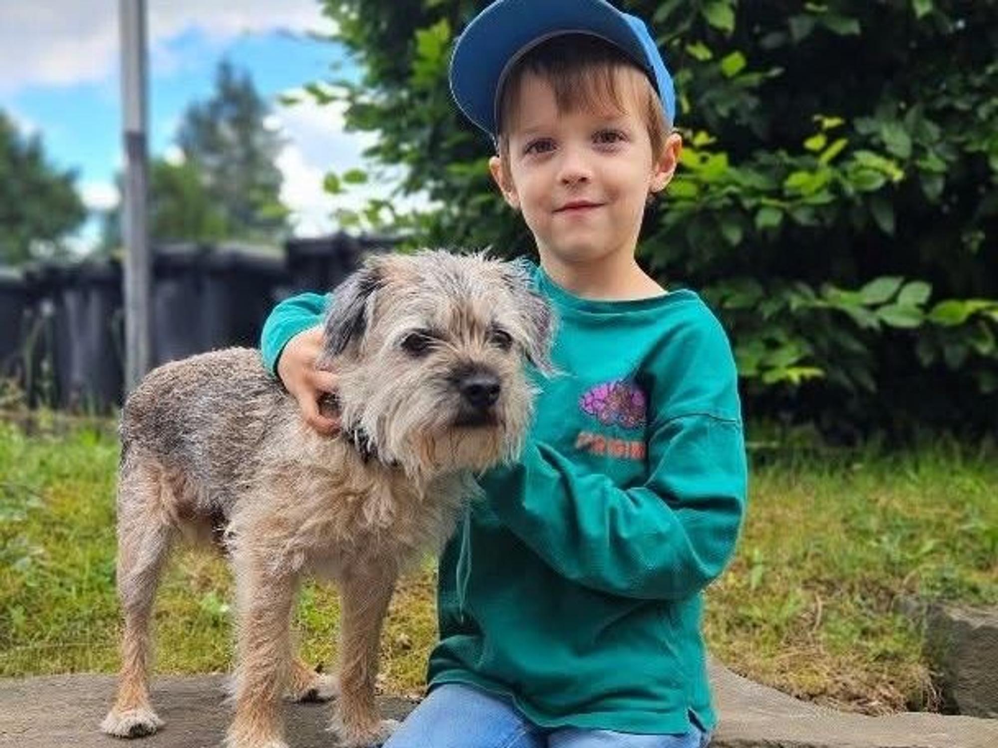 Bruno sitzt neben einem kleinen Hund.