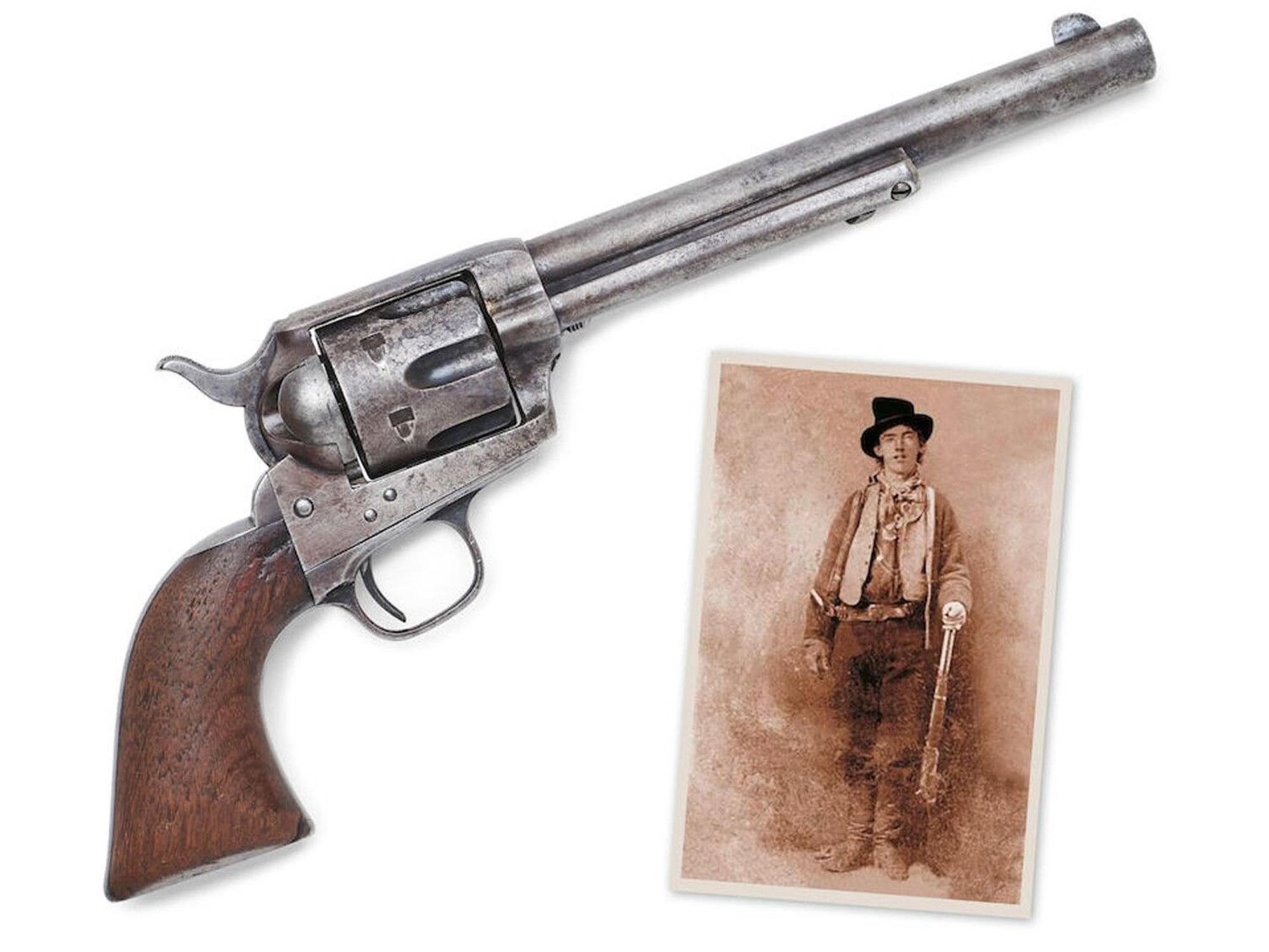 Ein Colt Single Action Revolver aus der Kollektion von Jim und Theresa Earle liegt neben einem Foto, das die Westernlegende Billy The Kid zeigt (undatiert).