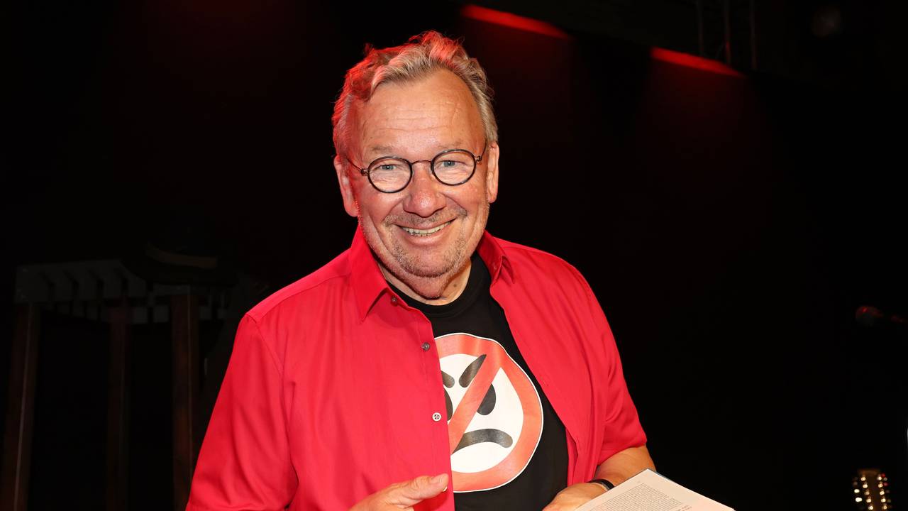 Bernd Stelter steht mit seinem Buch auf der Bühne.