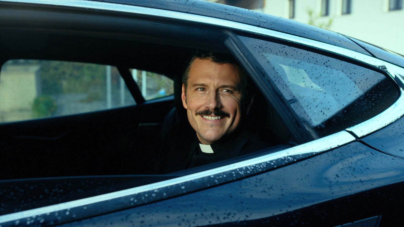 Auch der Geistliche Banyardi (Manuel Rubey) mischt in „Braunschlag 1986“ wieder mit. (Bild: © SUPERFILM)