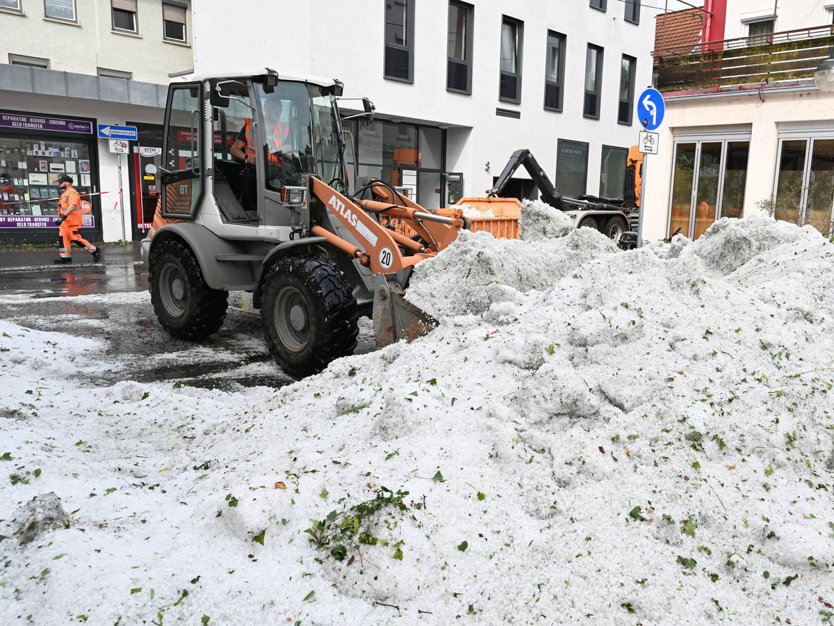 Mitarbeiter der Stadtreinigung entfernen in Reutlingen Hagel, der nach einem Unwetter in der Innenstadt aufgetürmt wurde.