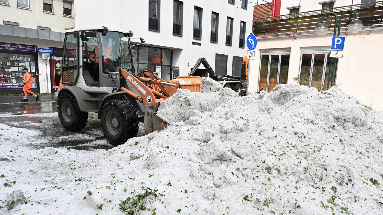 Mitarbeiter der Stadtreinigung entfernen in Reutlingen Hagel, der nach einem Unwetter in der Innenstadt aufgetürmt wurde.