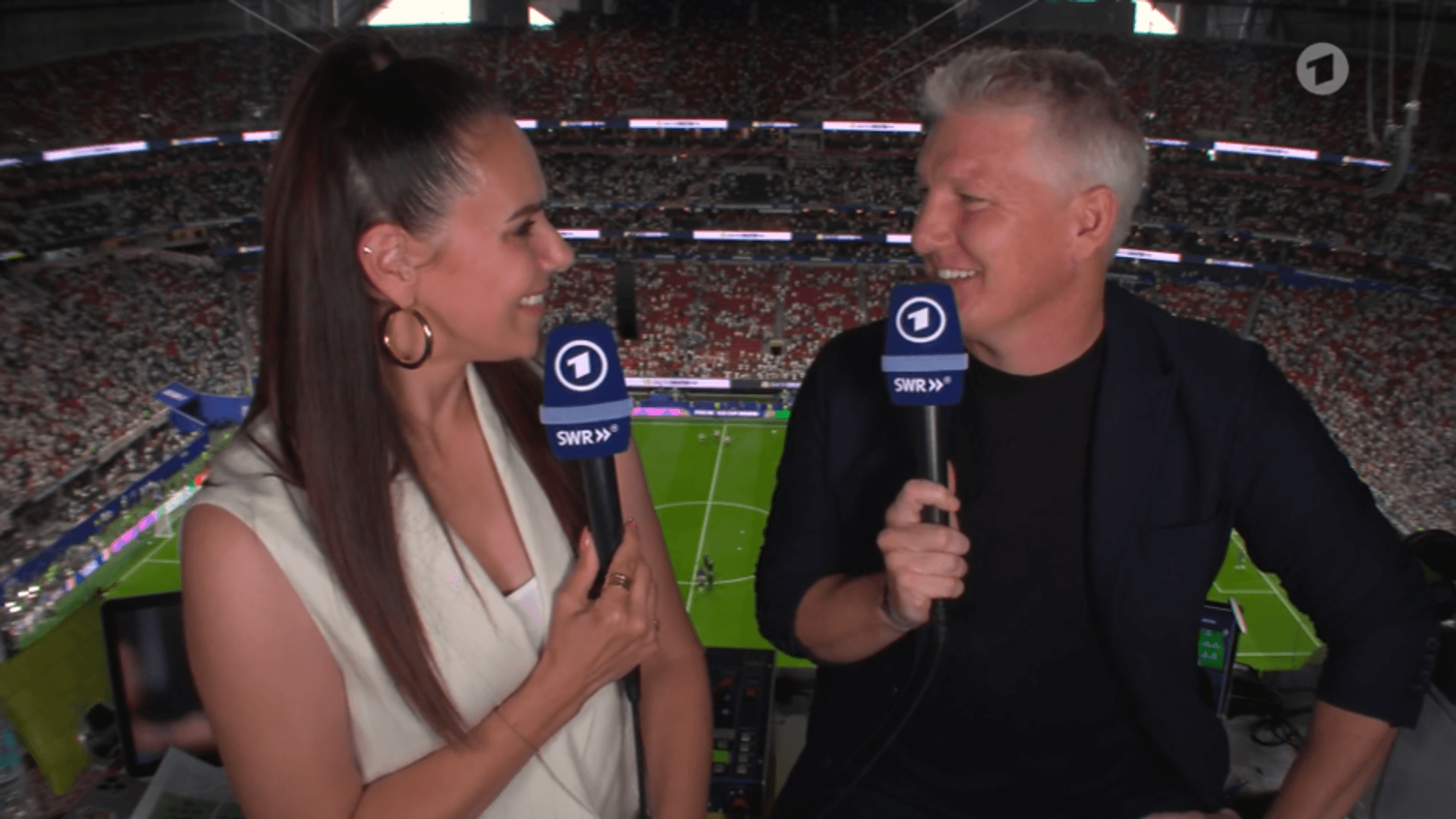Esther Sedlaczek und Bastian Schweinsteiger lächeln sich an.
