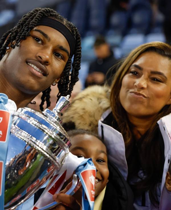 Reigan Heskey von Manchester City feiert mit seiner Familie den Gewinn des FA-Youth-Cup und hält eine Trophäe hoch.