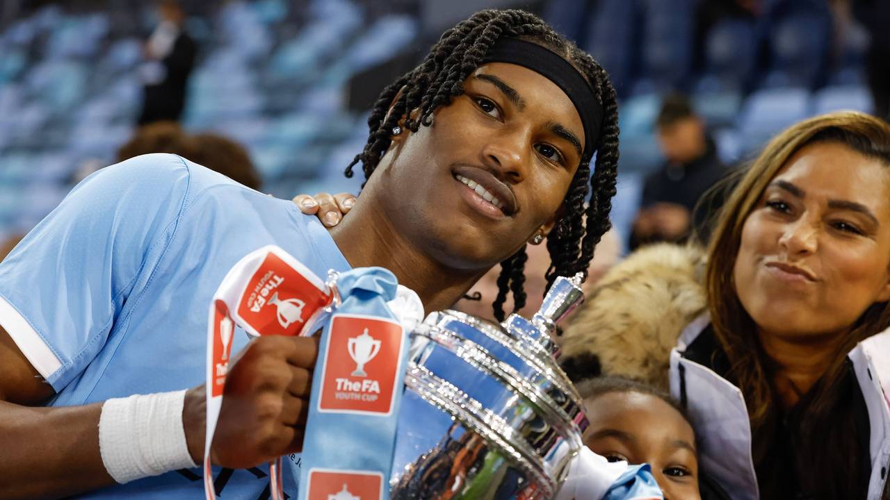 Reigan Heskey von Manchester City feiert mit seiner Familie den Gewinn des FA-Youth-Cup und hält eine Trophäe hoch.