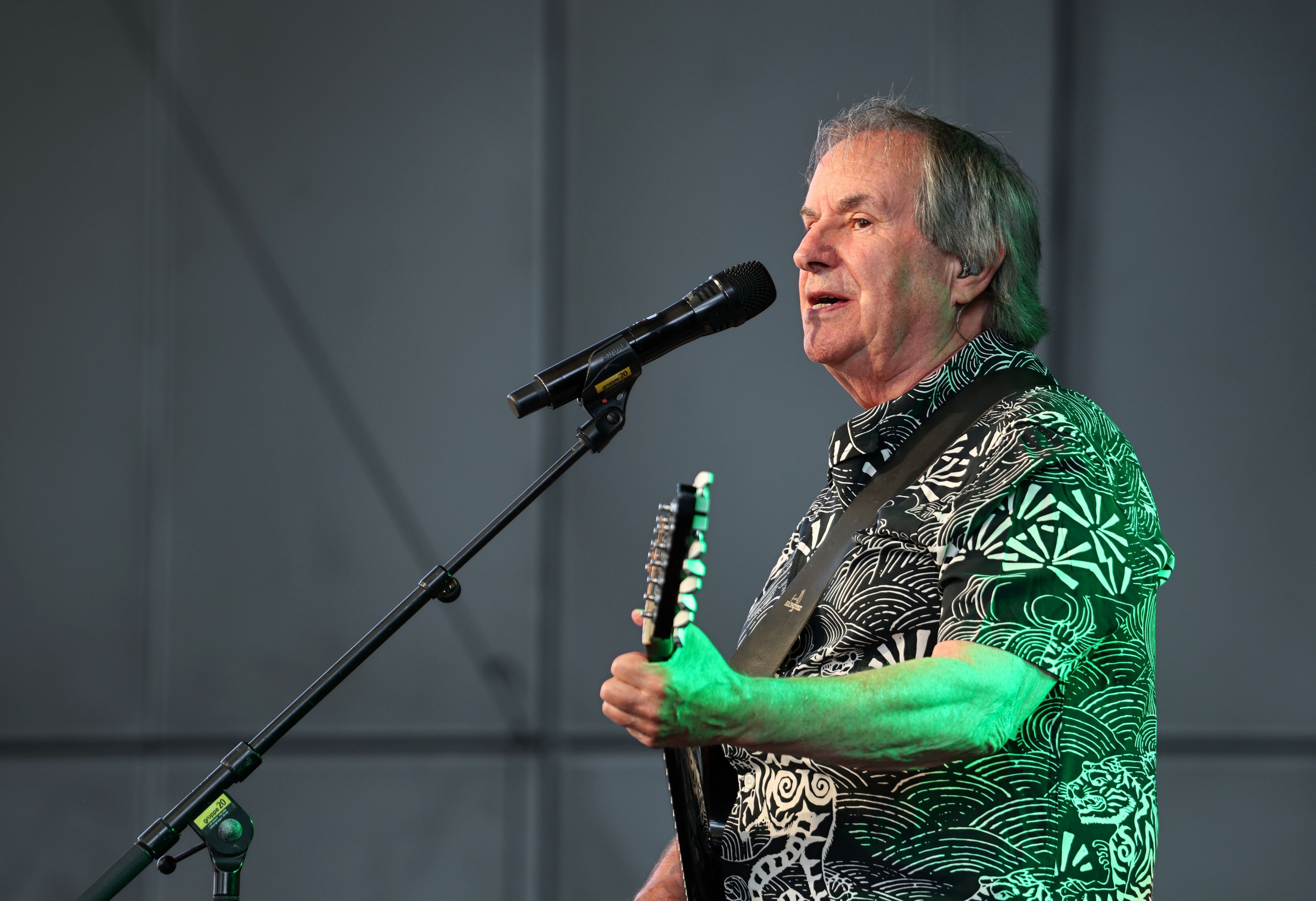 Chris de Burgh steht mit seiner Gitarre auf der Bühne.