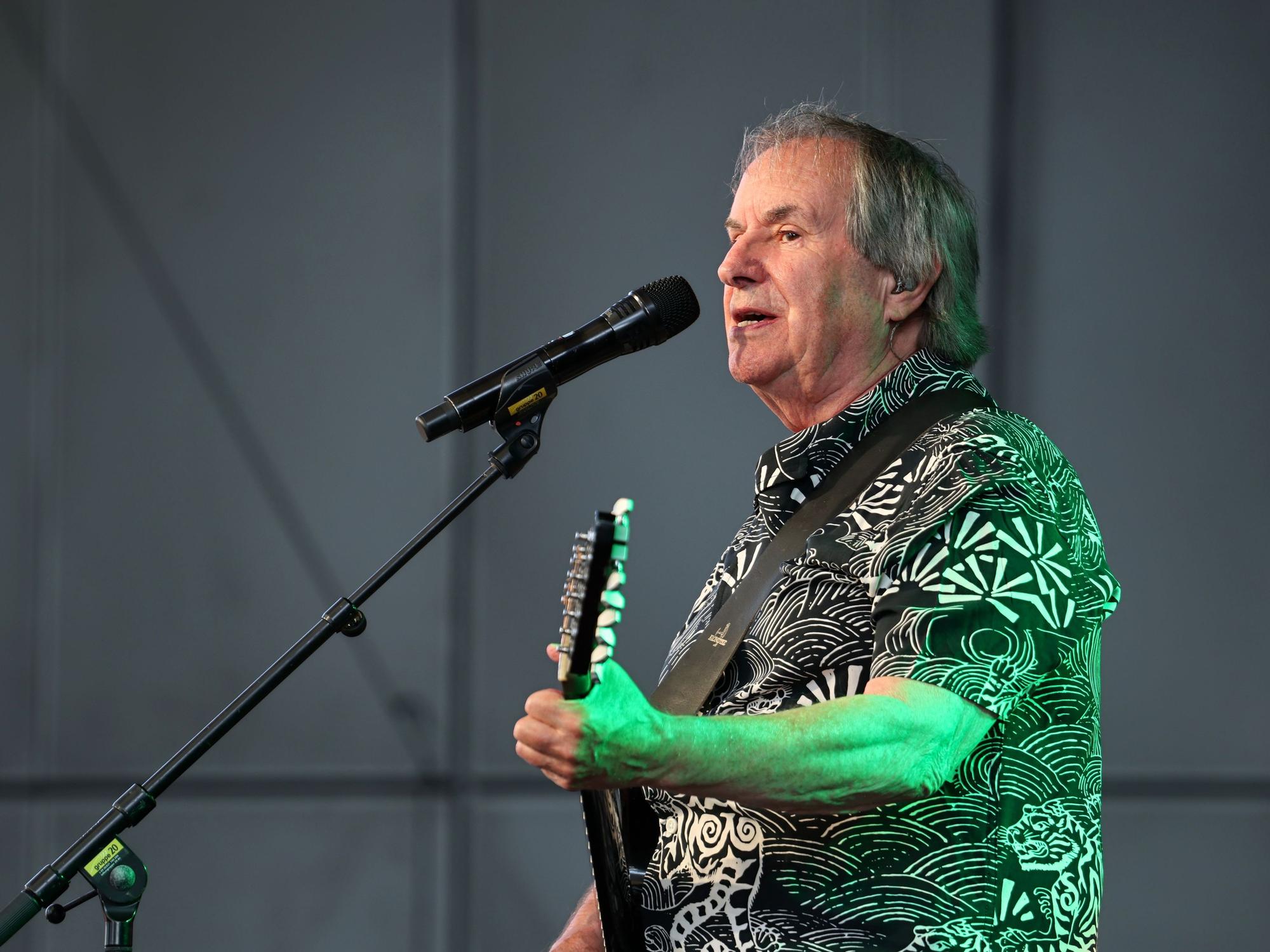 Chris de Burgh steht mit seiner Gitarre auf der Bühne.