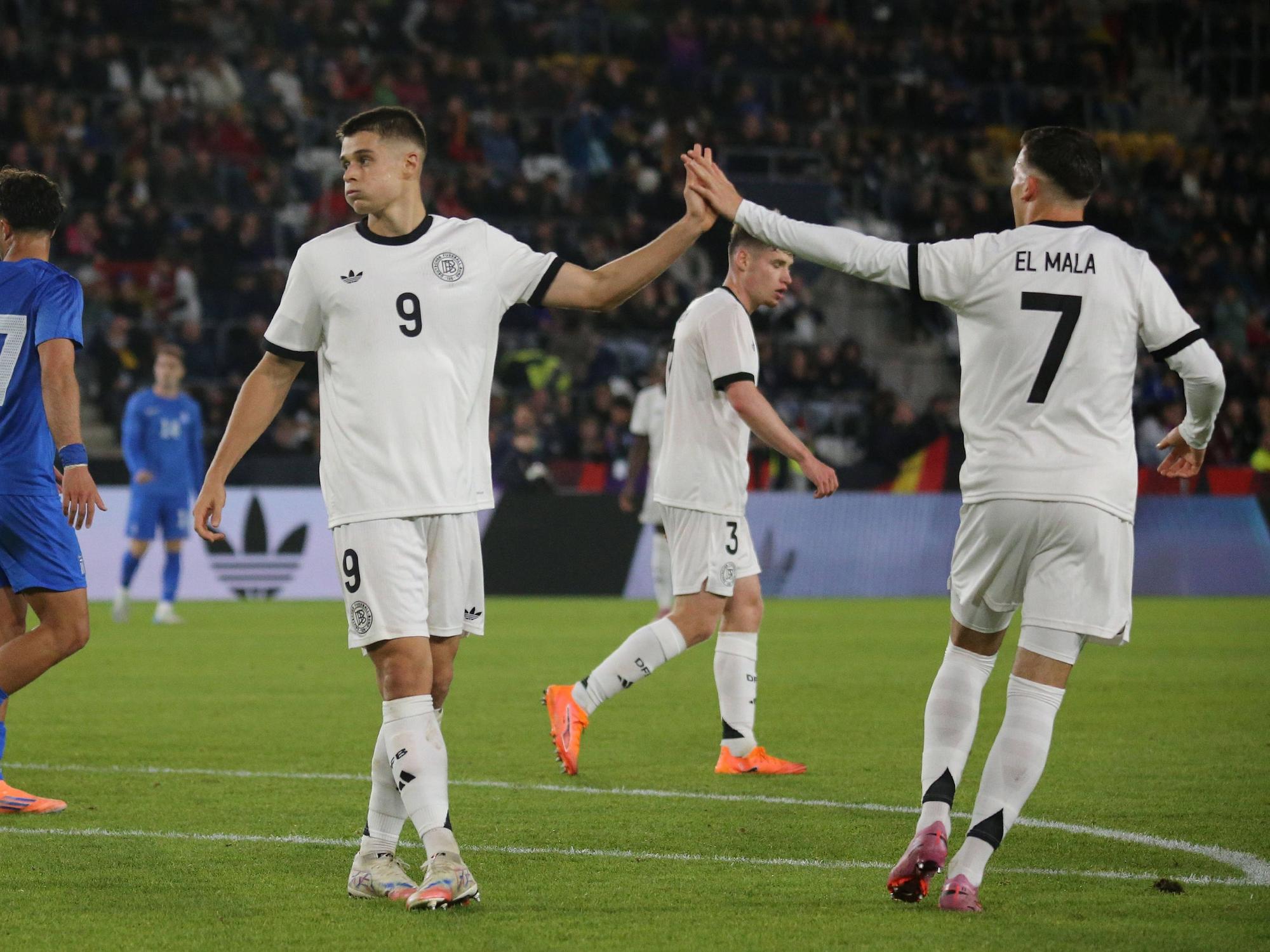 Nicolo Tresoldi und Said El Mala klatschen bei einem Spiel der U21 des DFB auf dem Feld ab.