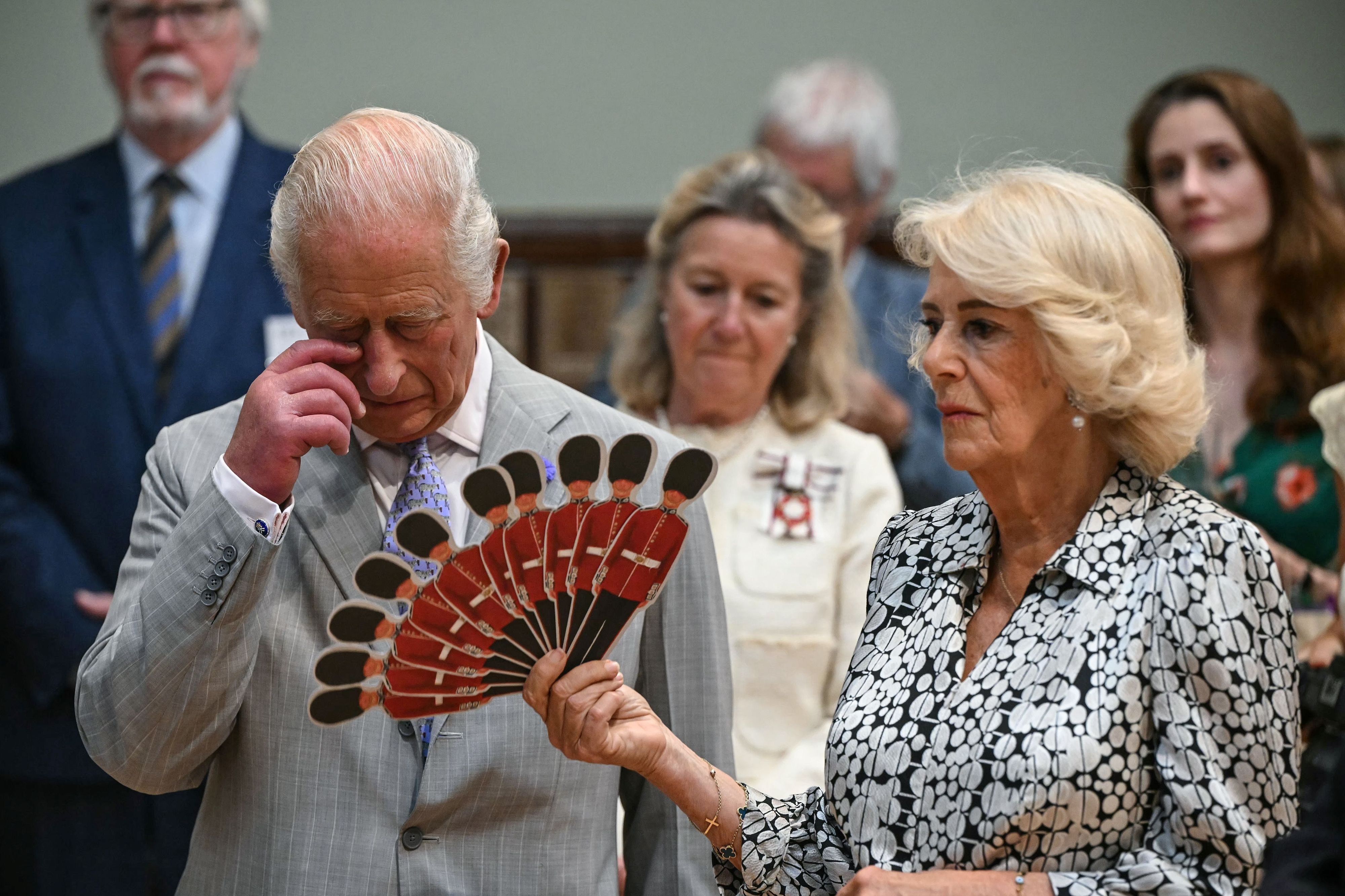 Königin Camilla fächelt König Charles III. Luft zu, während sie einer Aufführung der Dorset Opera lauschen.