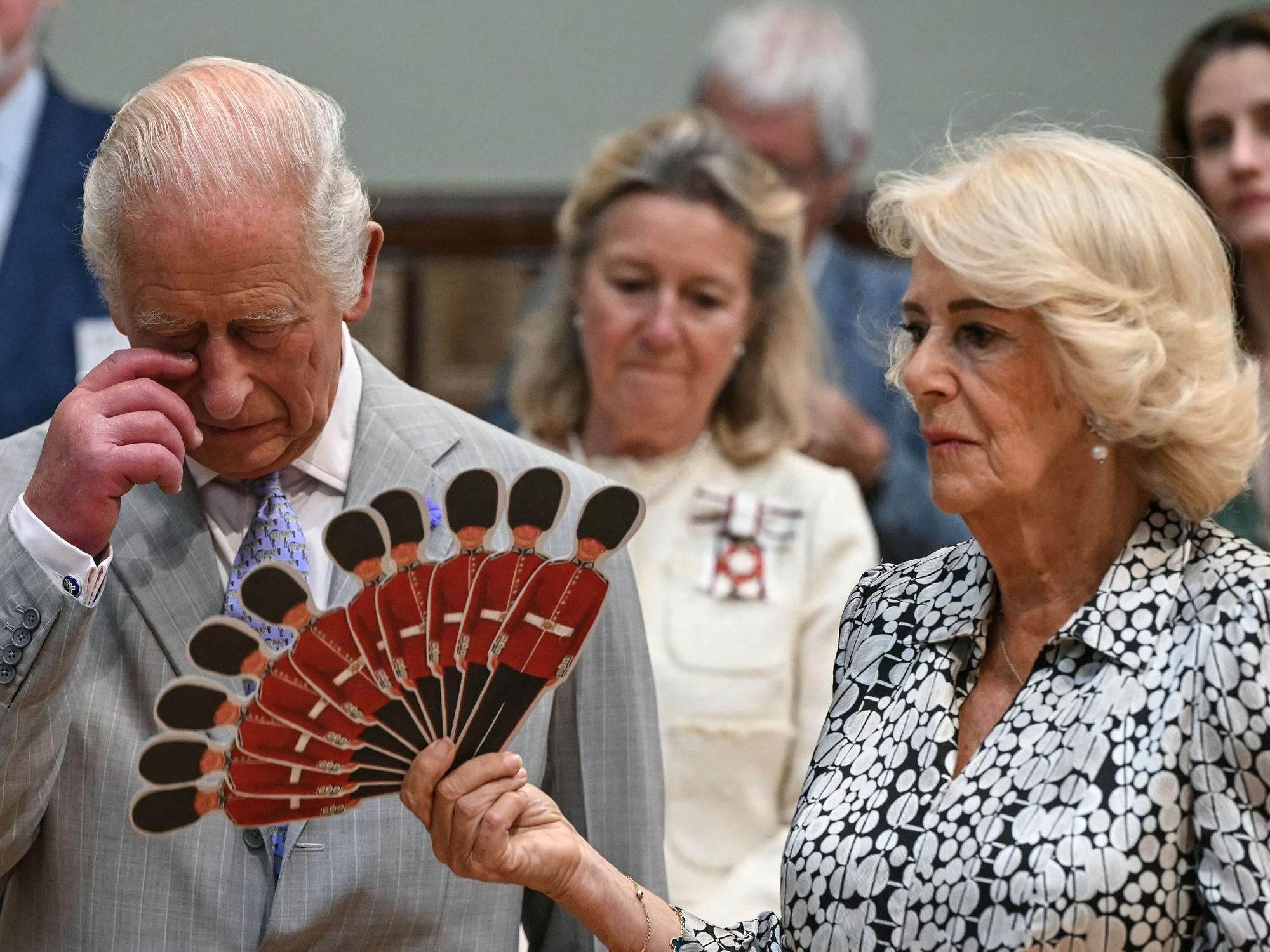 Königin Camilla fächelt König Charles III. Luft zu, während sie einer Aufführung der Dorset Opera lauschen.