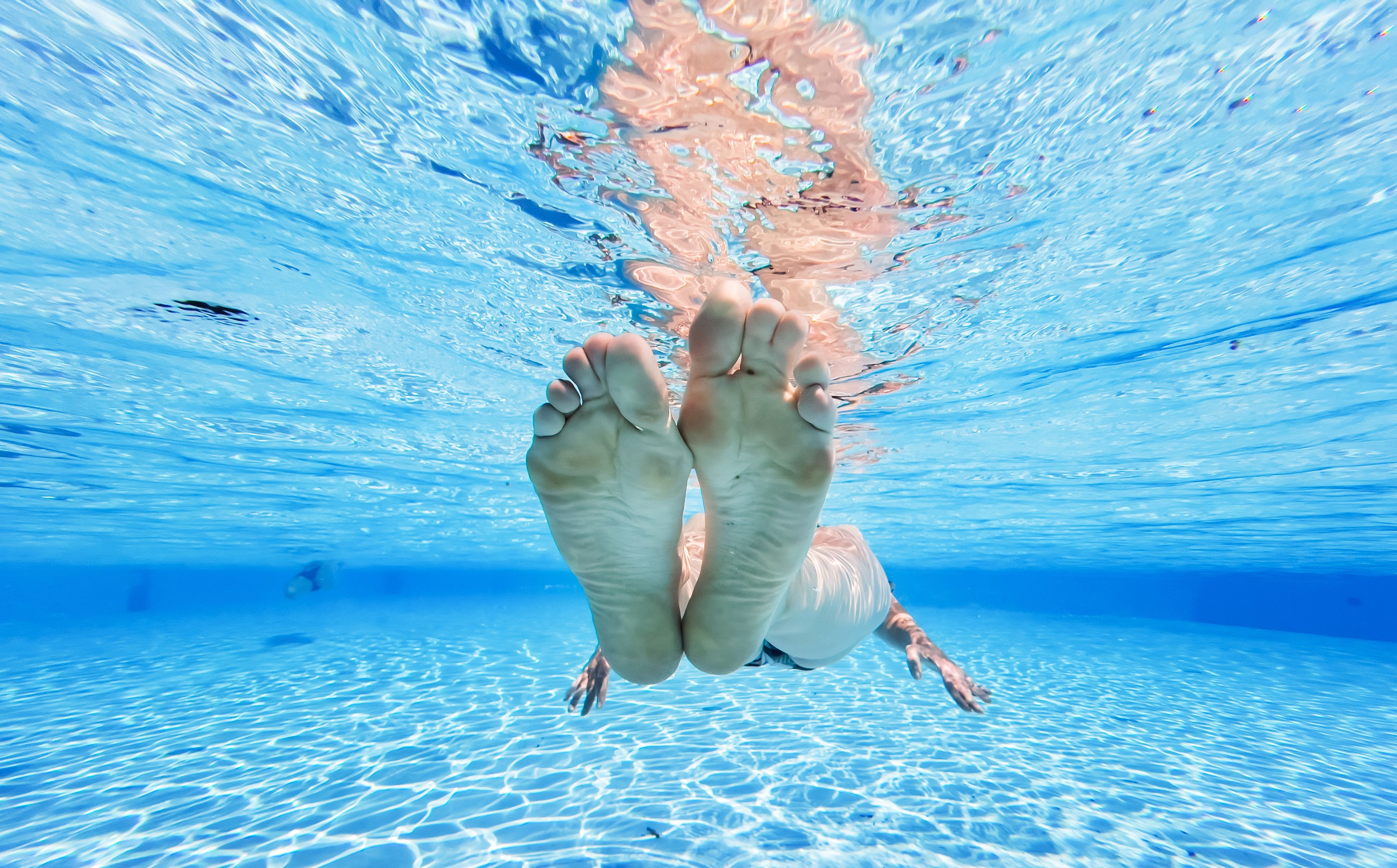 Eine Frau treibt im kühlen Wasser eines privaten Pools in der Region Hannover.
