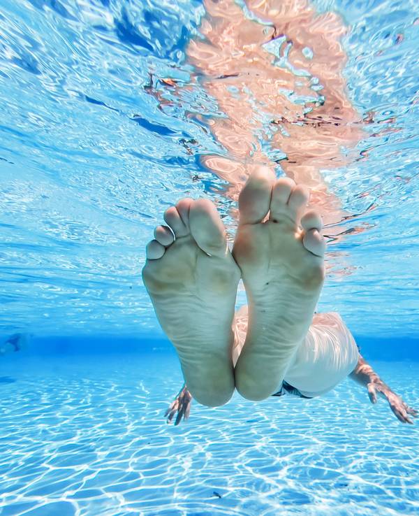 Eine Frau treibt im kühlen Wasser eines privaten Pools in der Region Hannover.