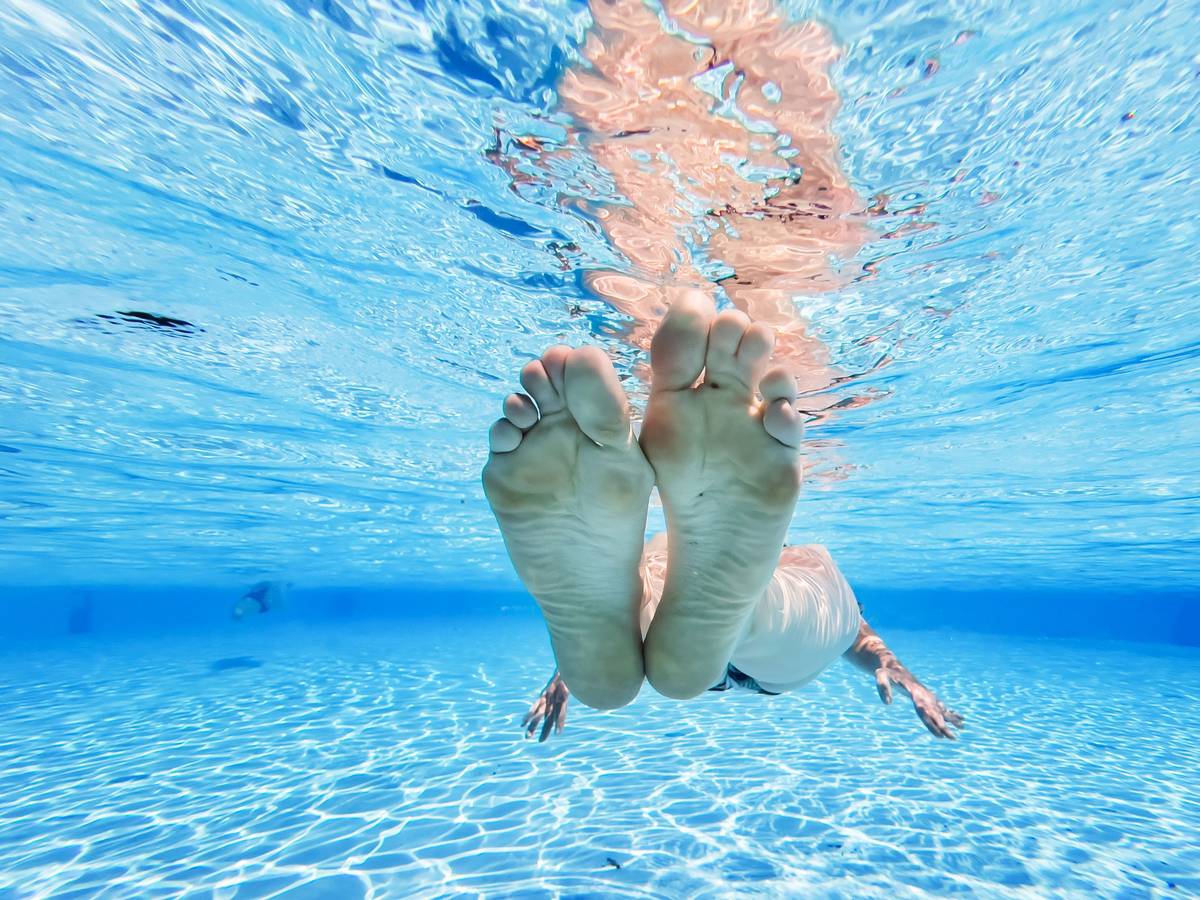 Eine Frau treibt im kühlen Wasser eines privaten Pools in der Region Hannover.
