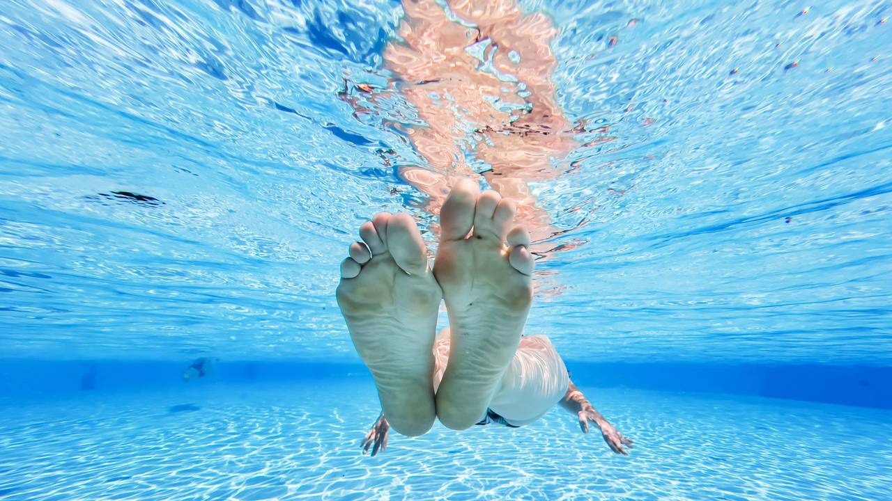 Eine Frau treibt im kühlen Wasser eines privaten Pools in der Region Hannover.
